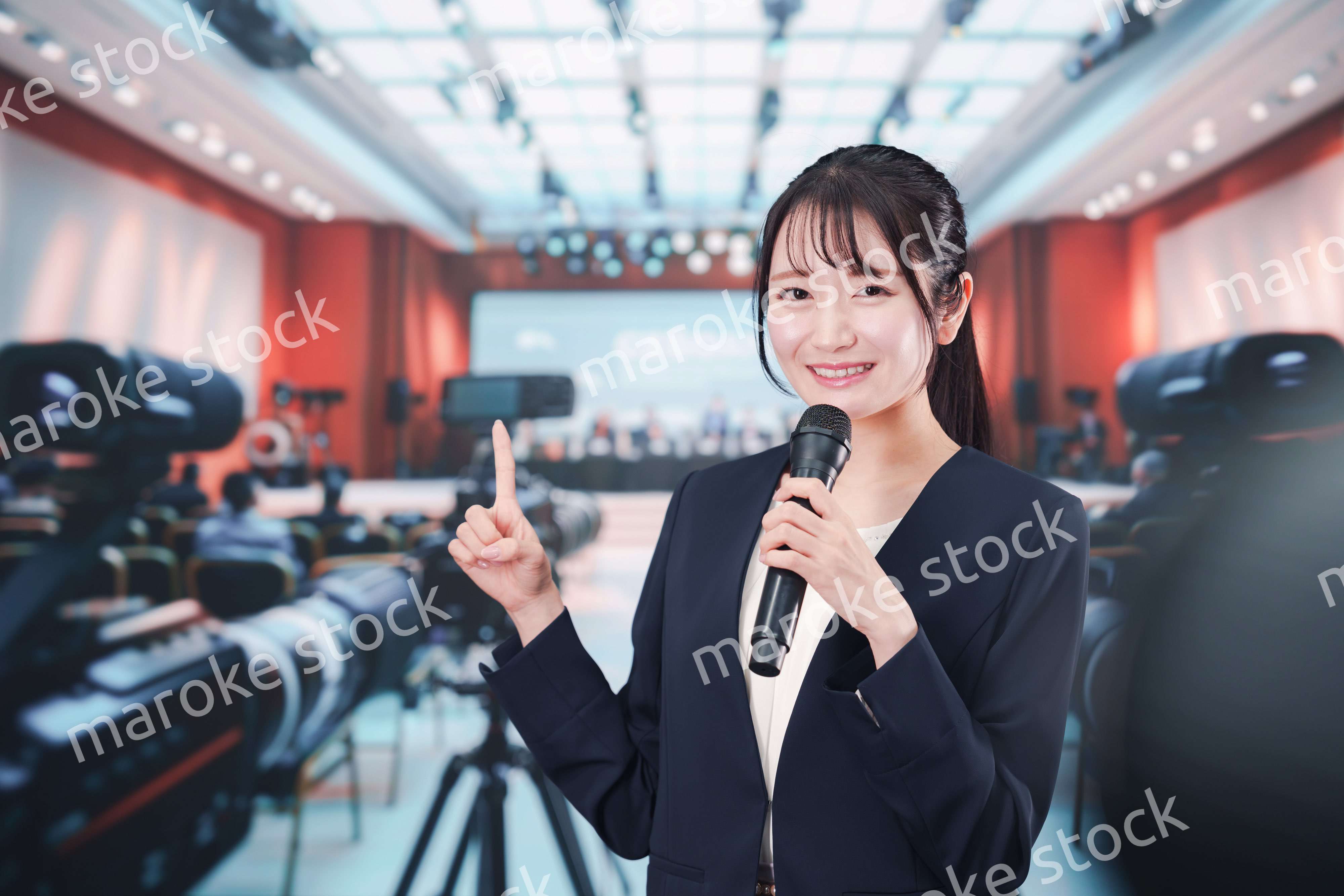 記者会見場からレポートをする女性記者