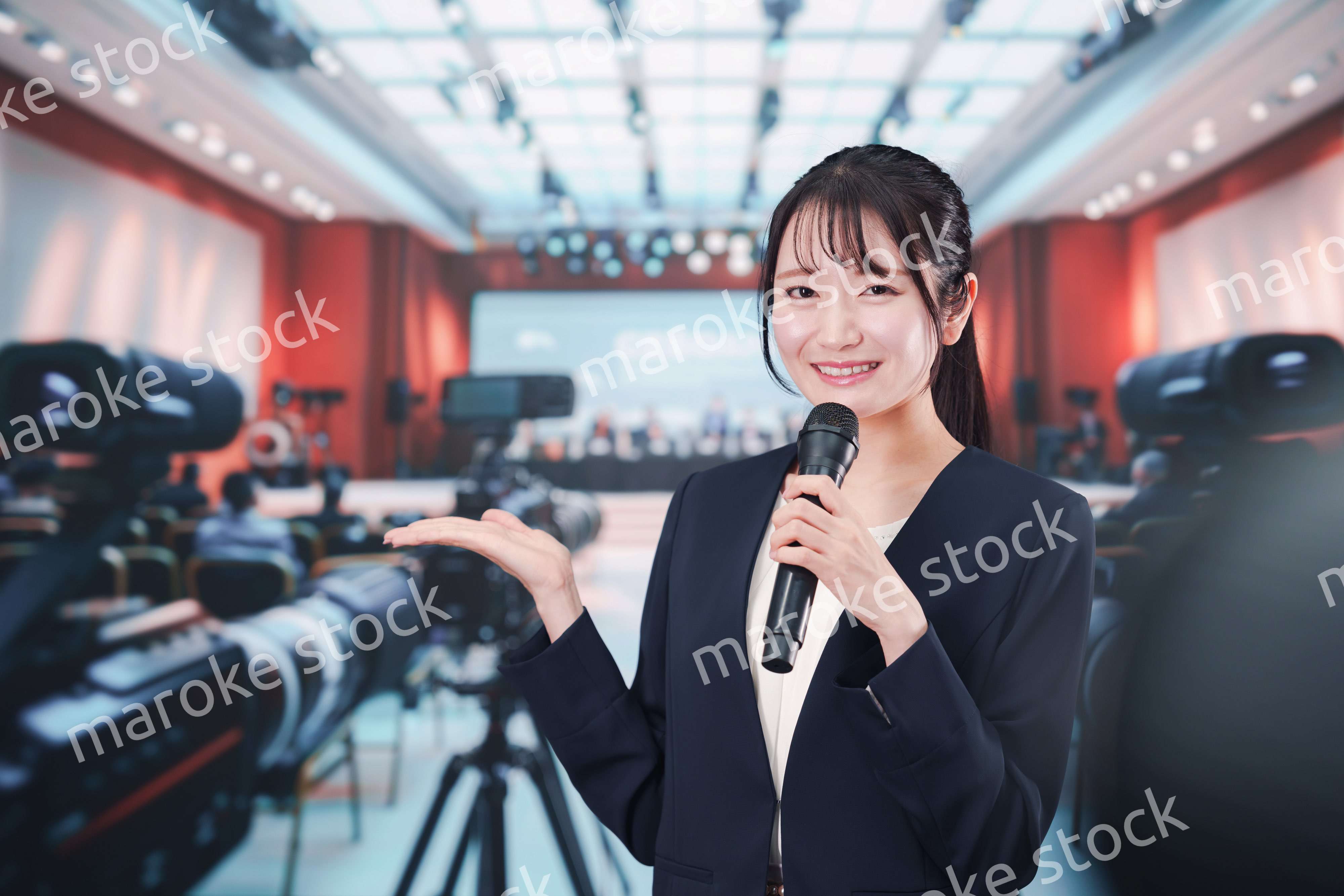 記者会見場からレポートをする女性記者