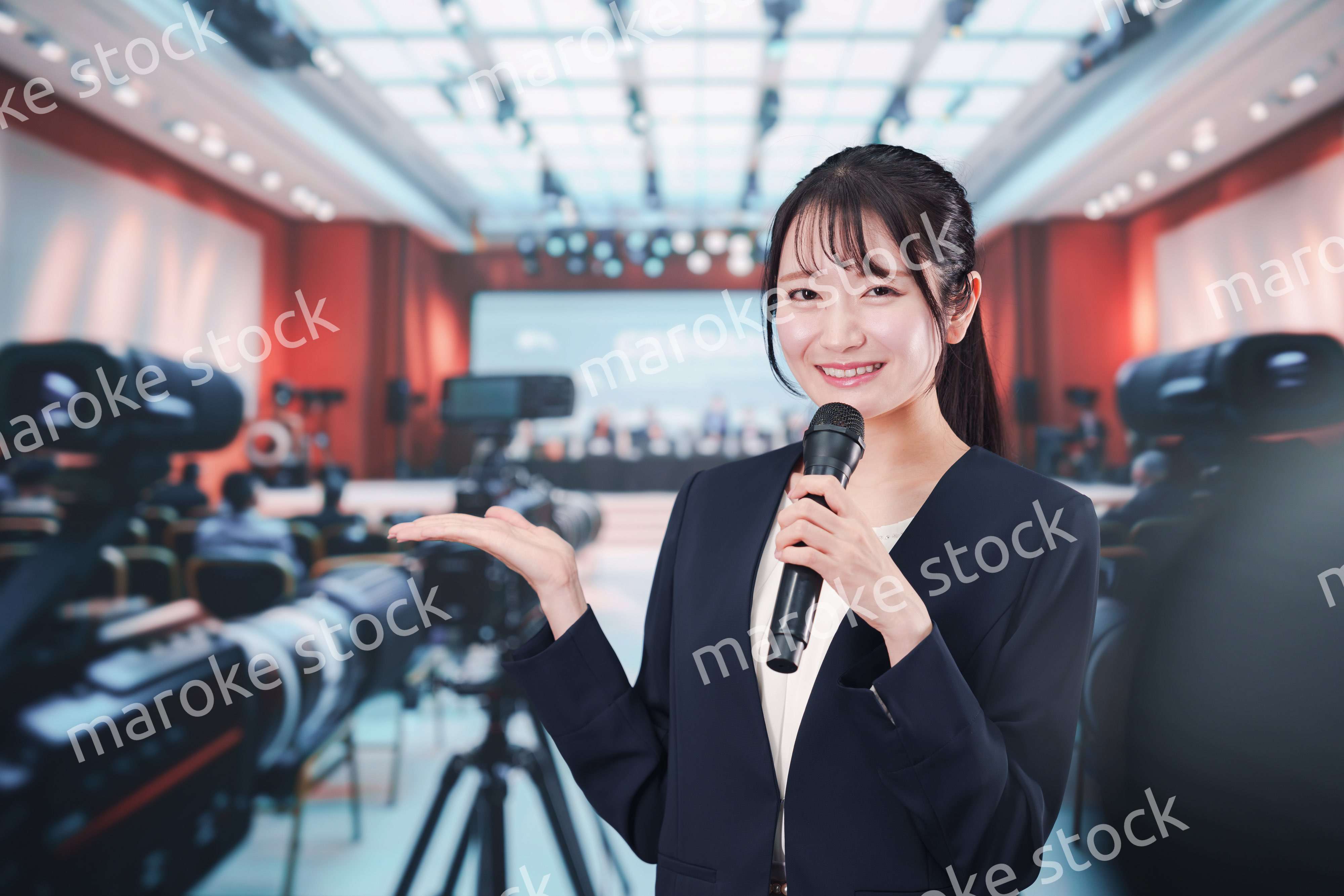 記者会見場からレポートをする女性記者