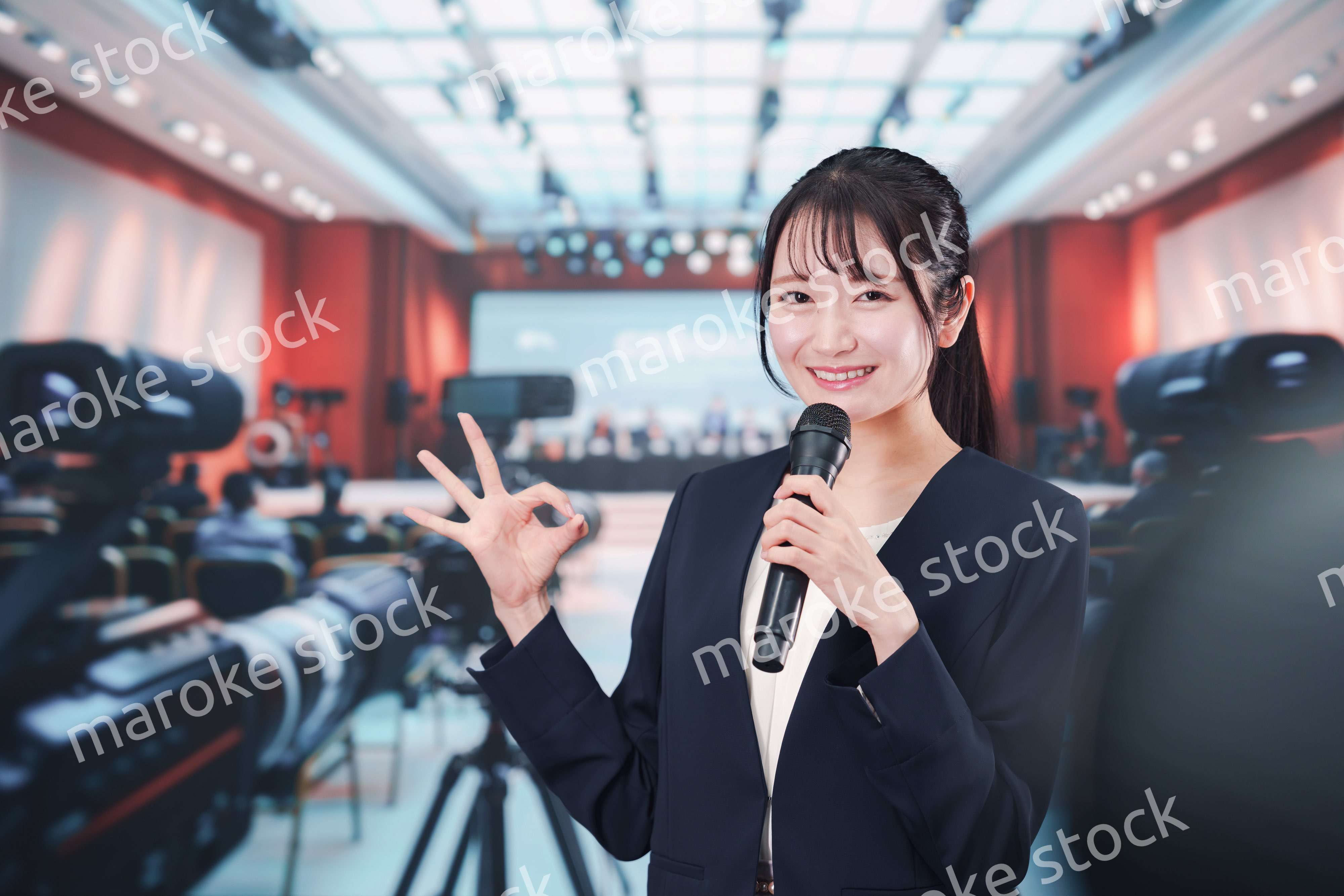 記者会見場からレポートをする女性記者