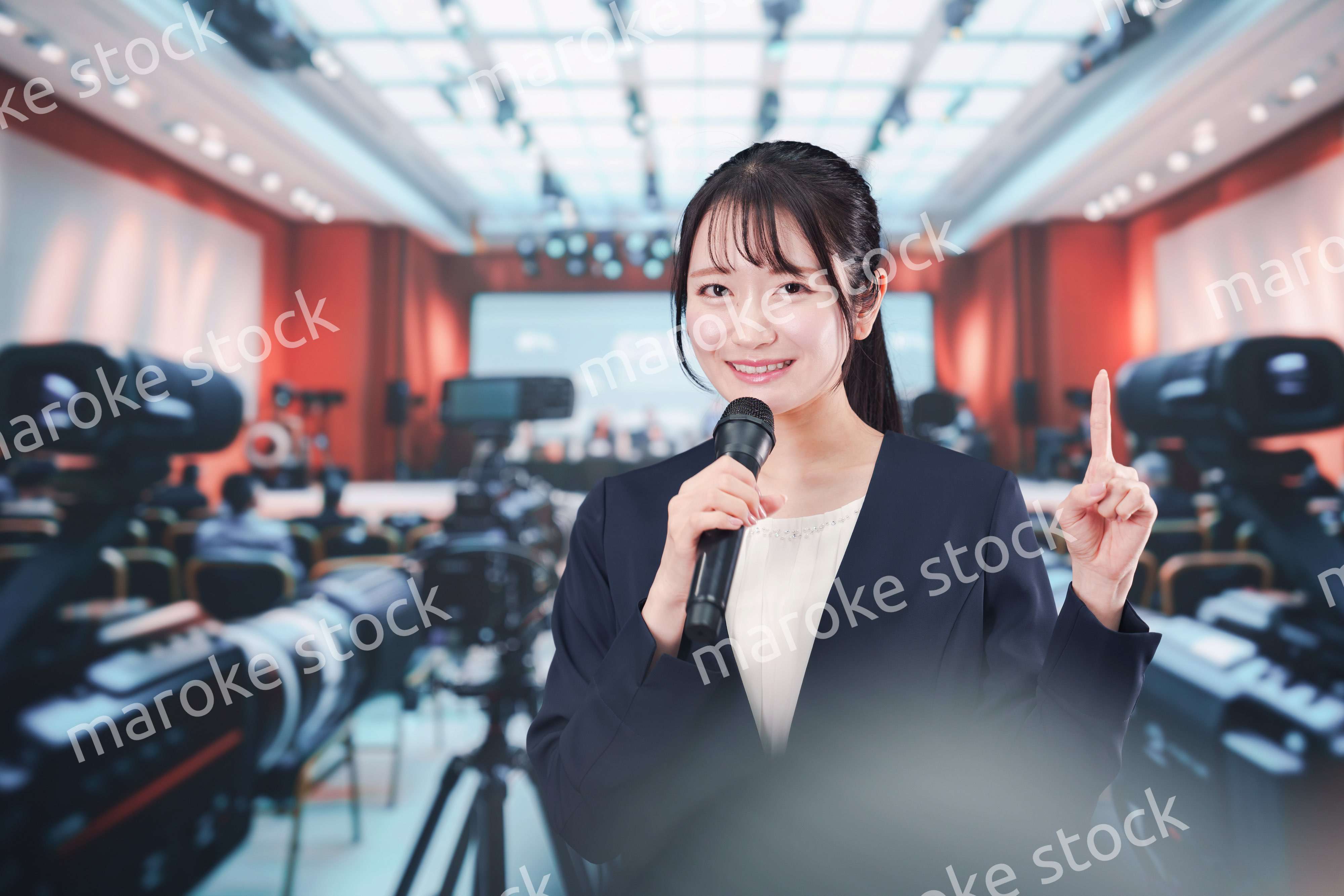 記者会見場からレポートをする女性記者