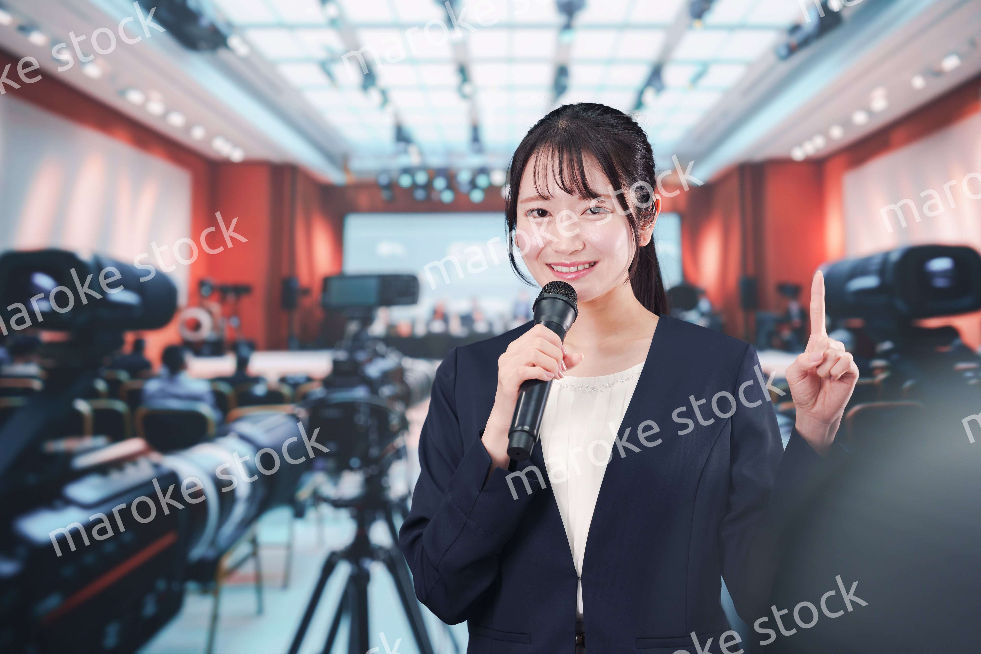 記者会見場からレポートをする女性記者