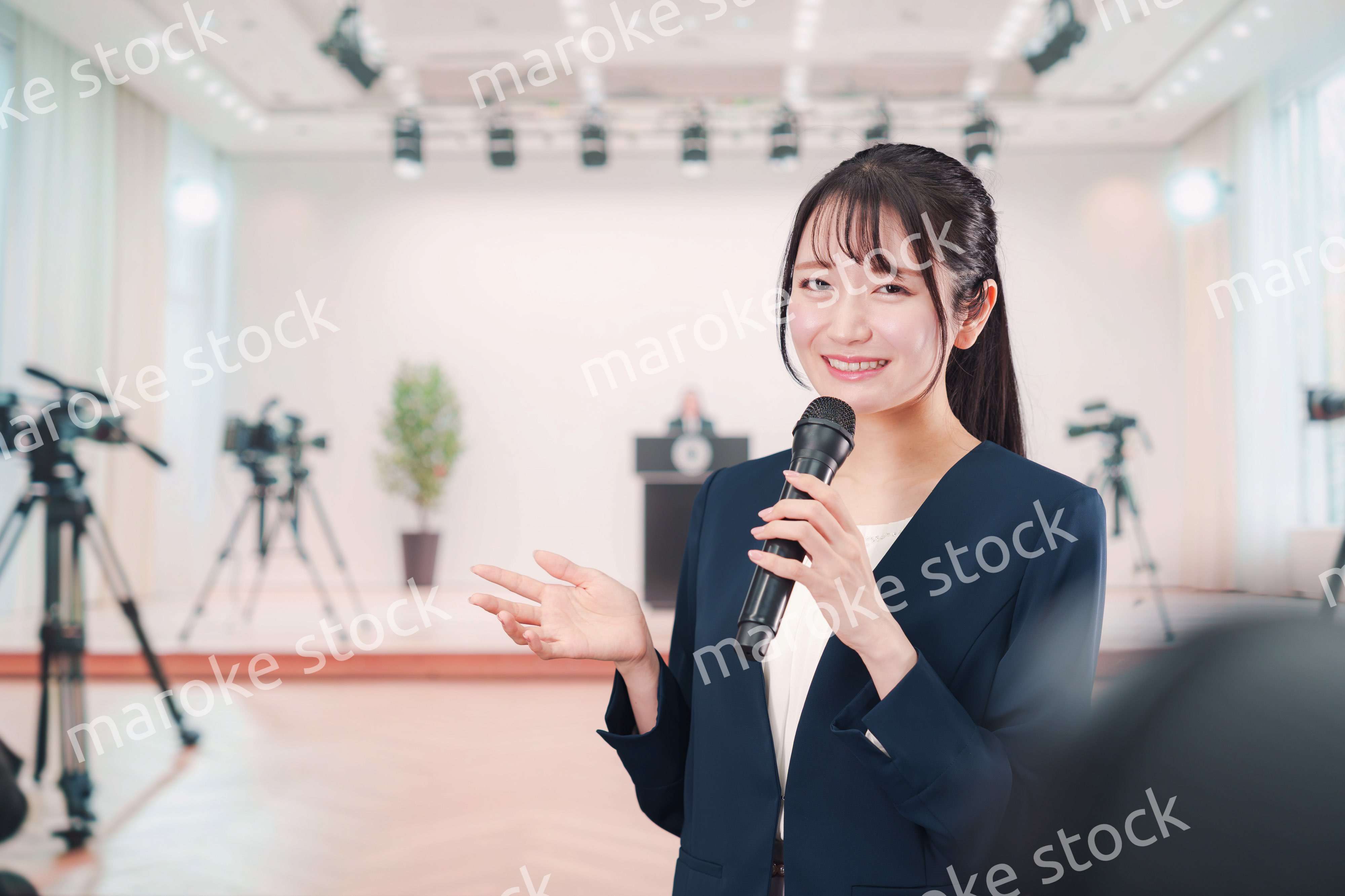 記者会見場からレポートをする女性のアナウンサー