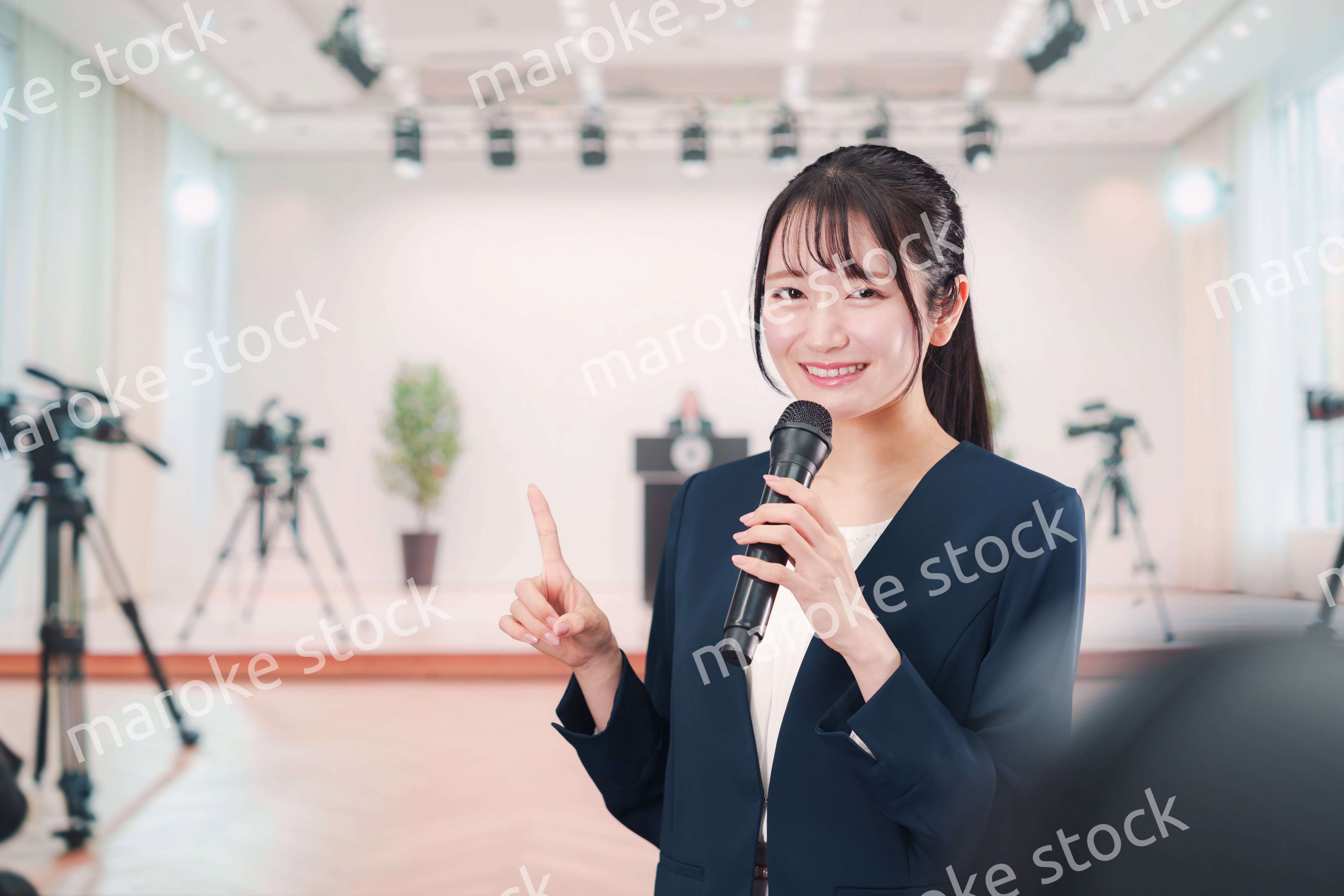 記者会見場からレポートをする女性のアナウンサー