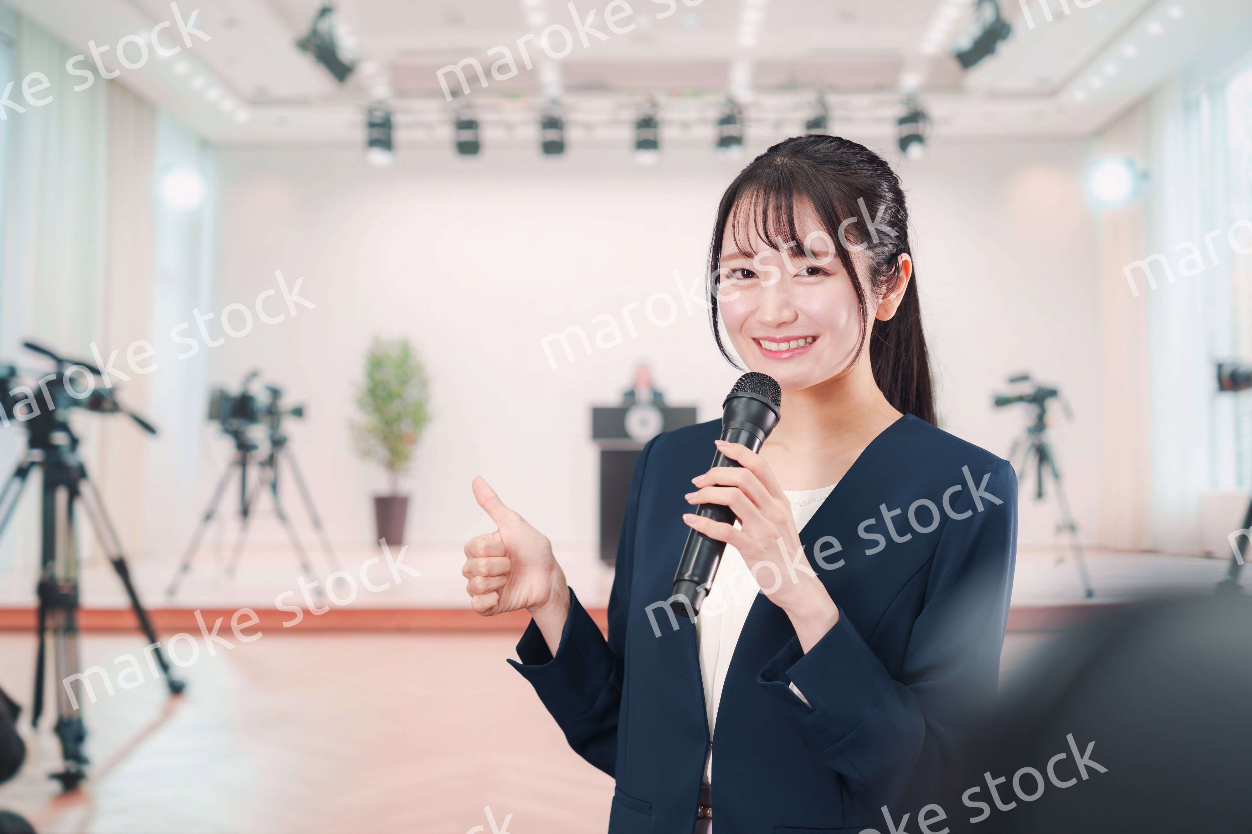 記者会見場からレポートをする女性のアナウンサー