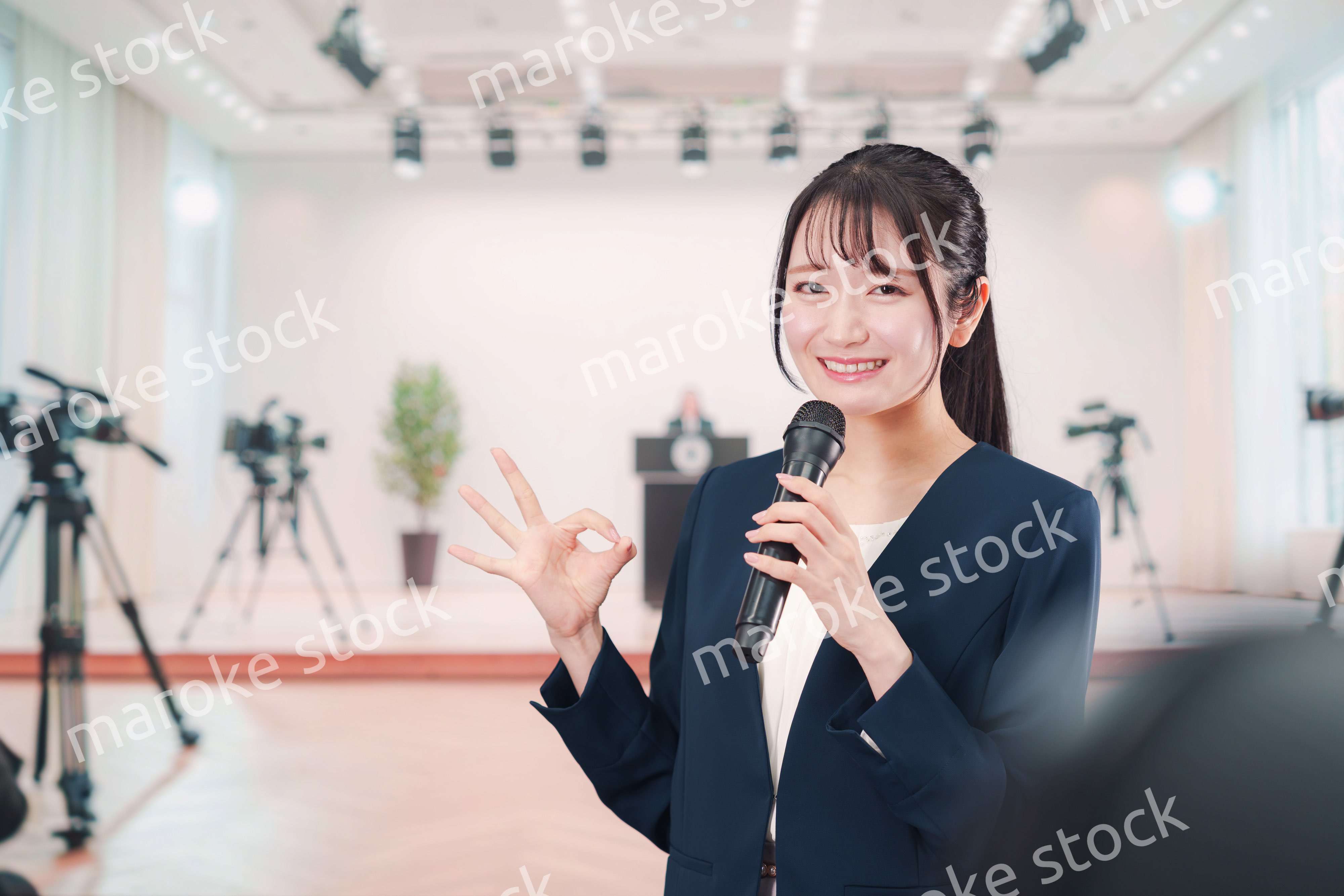 記者会見場からレポートをする女性のアナウンサー