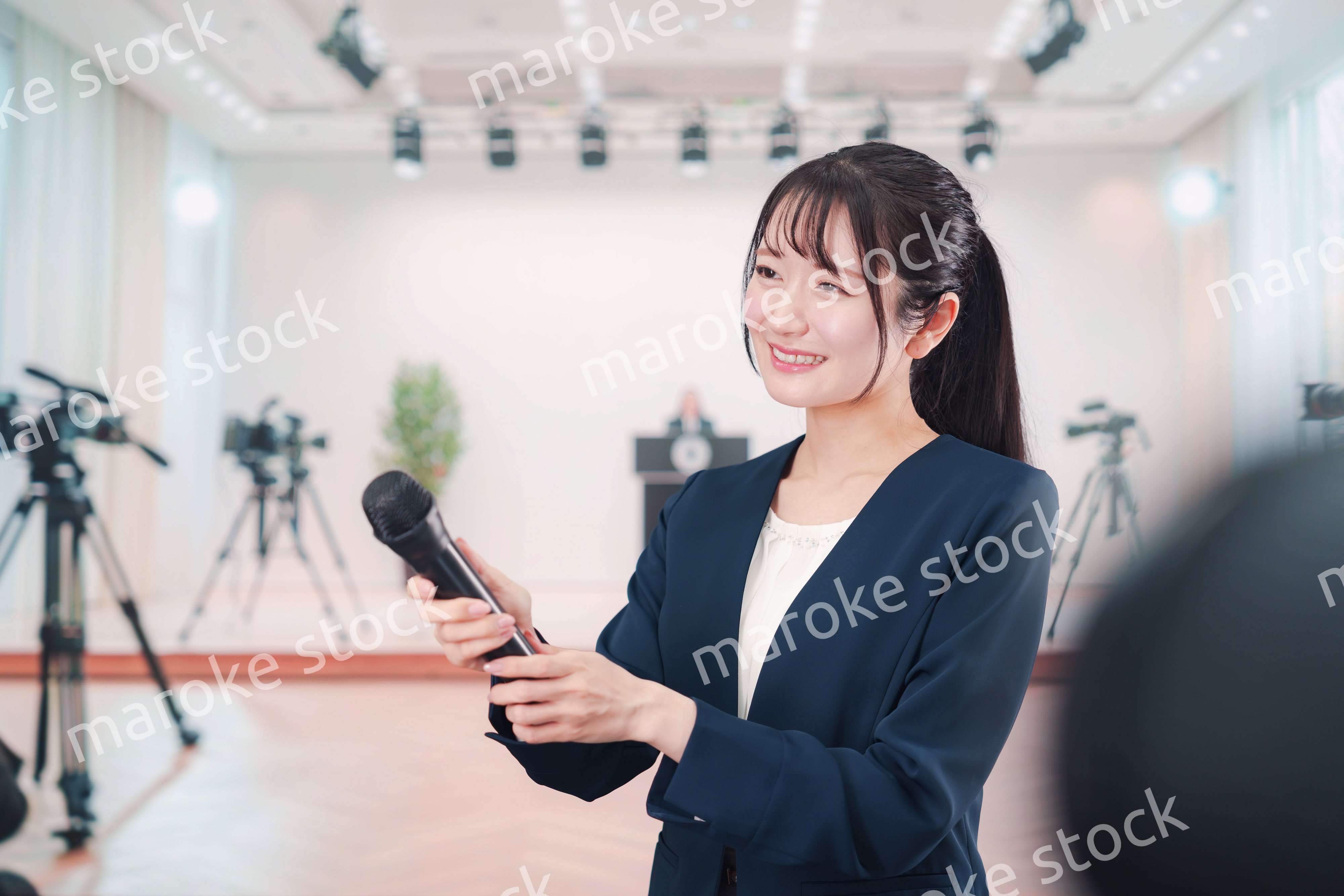 カメラの前でインタビューをする広報担当の女性