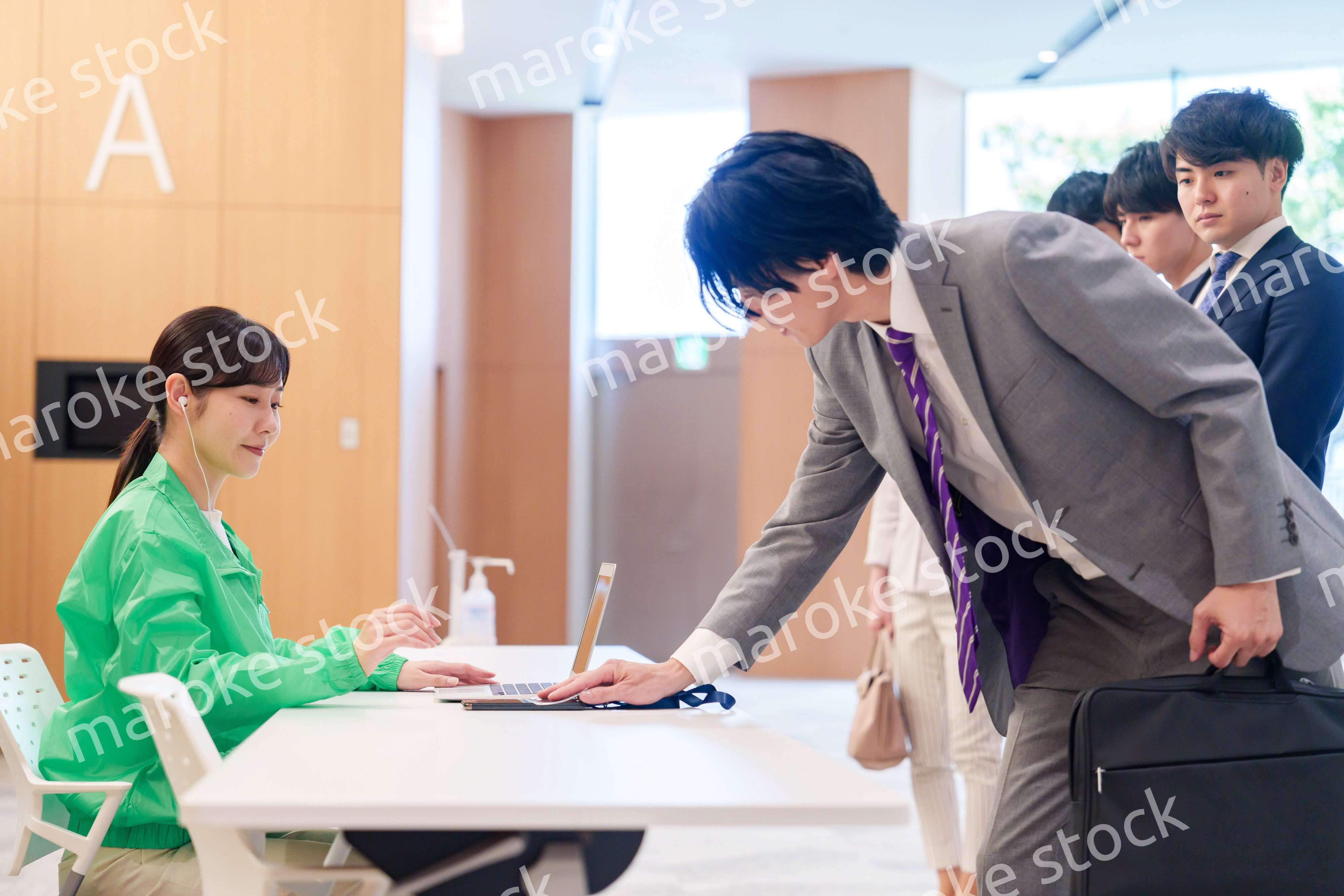 カンファレンスの受付スタッフと参加者