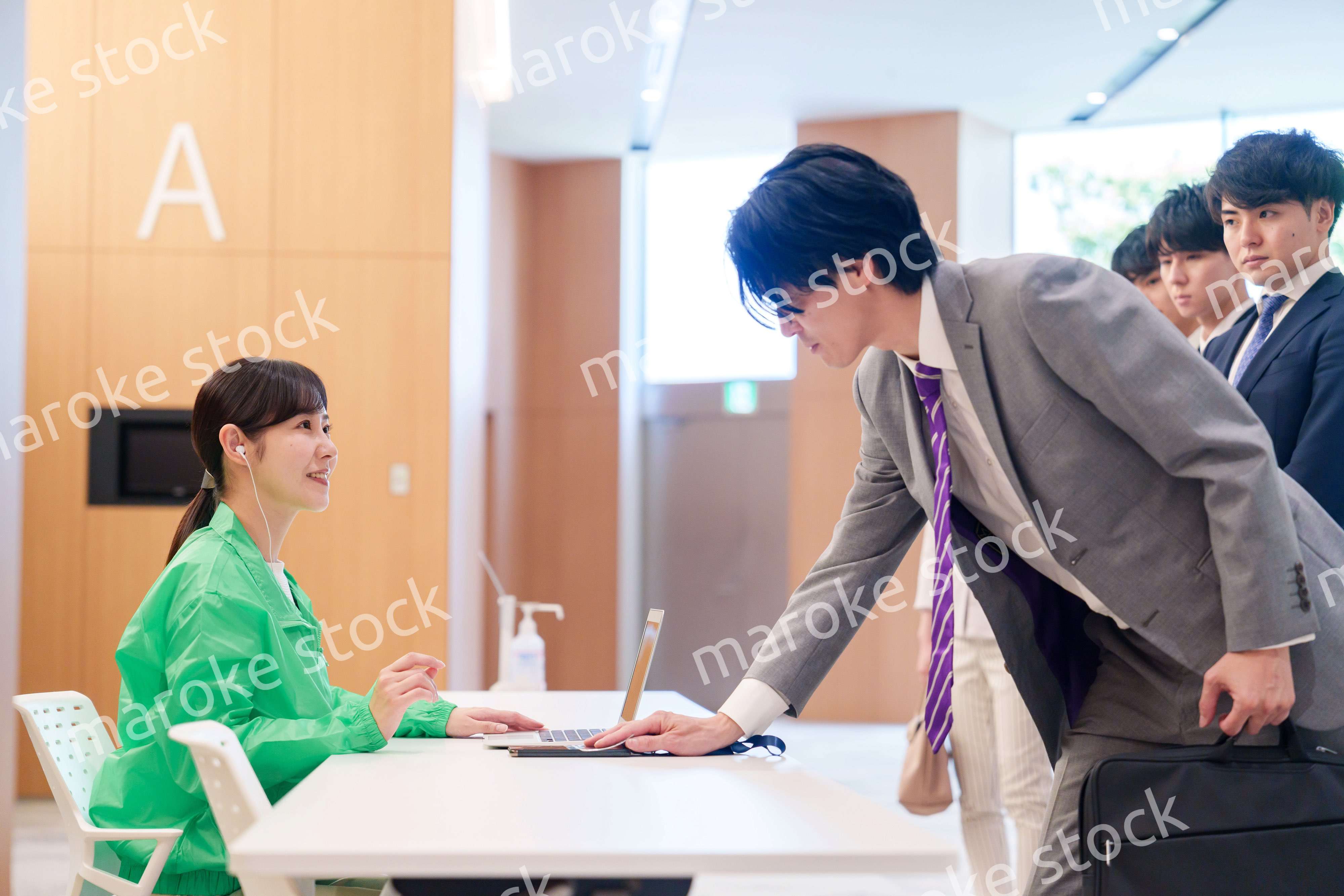 カンファレンスの受付スタッフと参加者