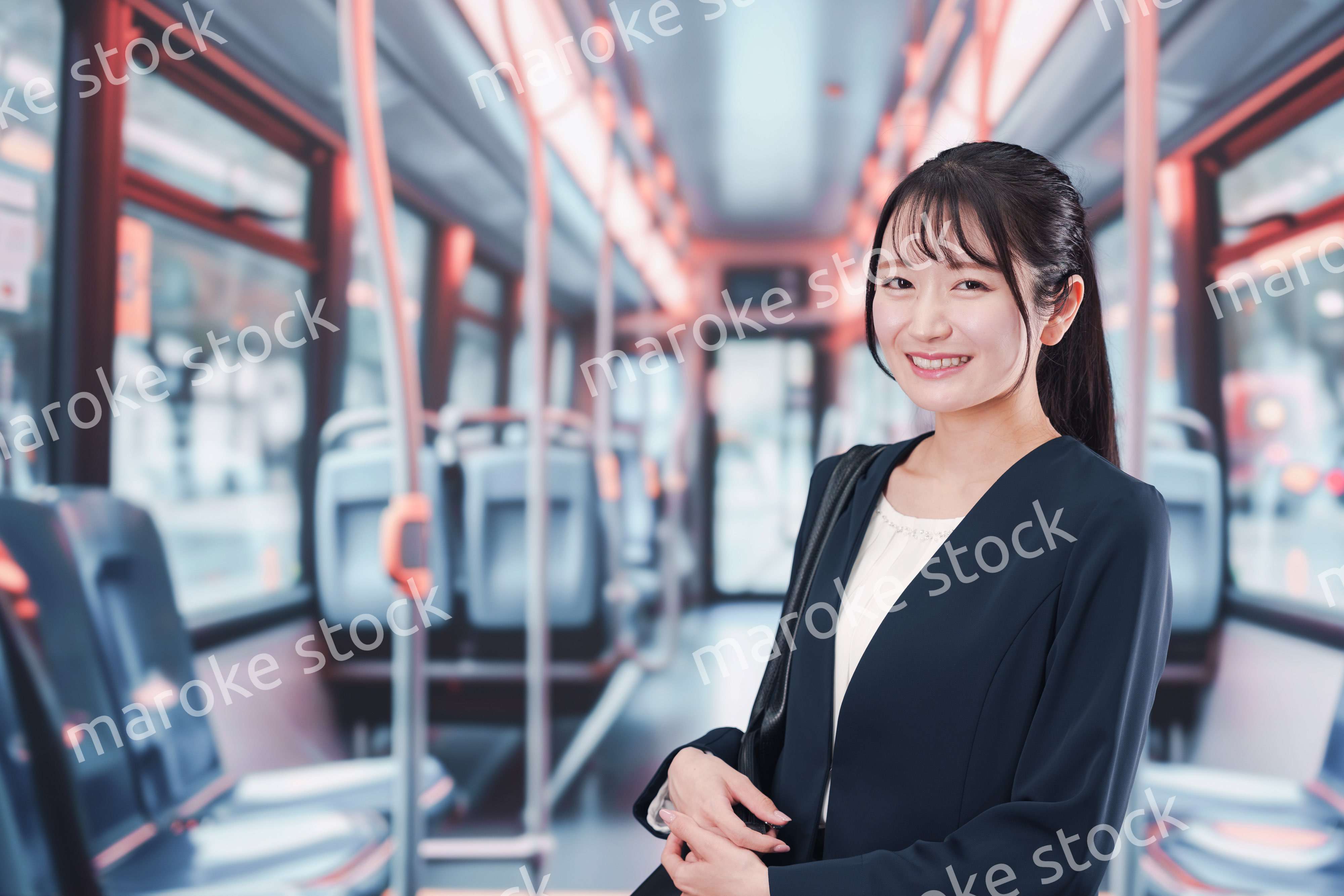 バスに乗って通勤をする若い女性