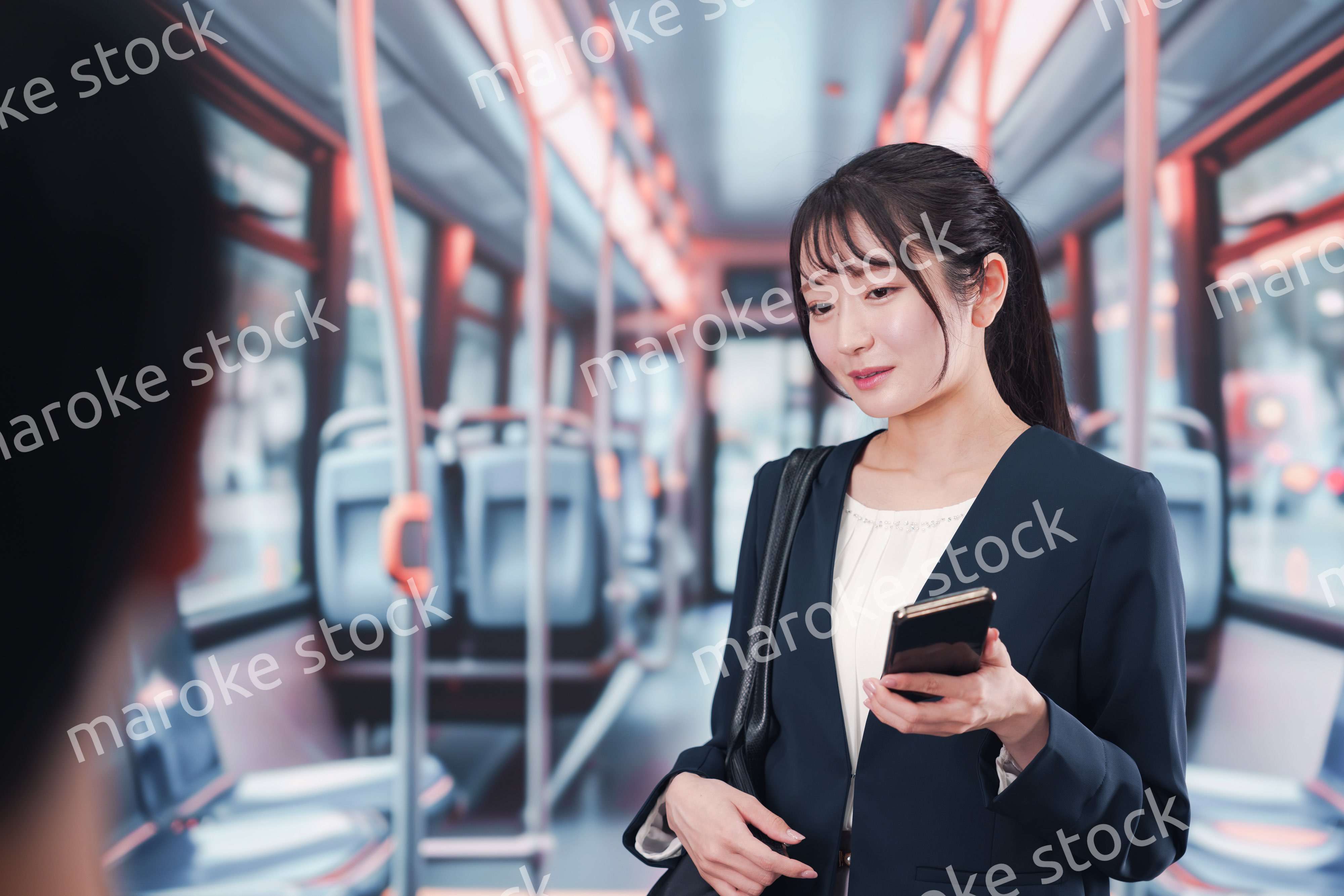 バスに乗って通勤をする若い女性