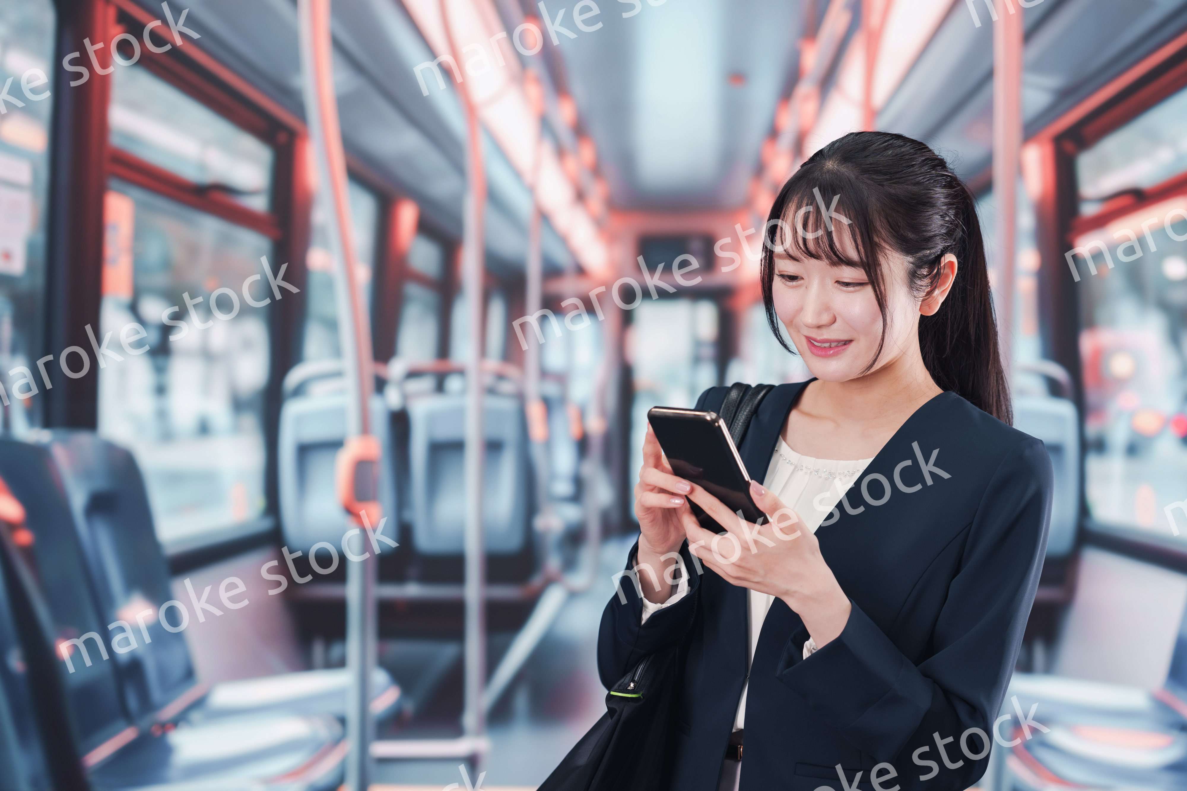 バスに乗って通勤をする若い女性