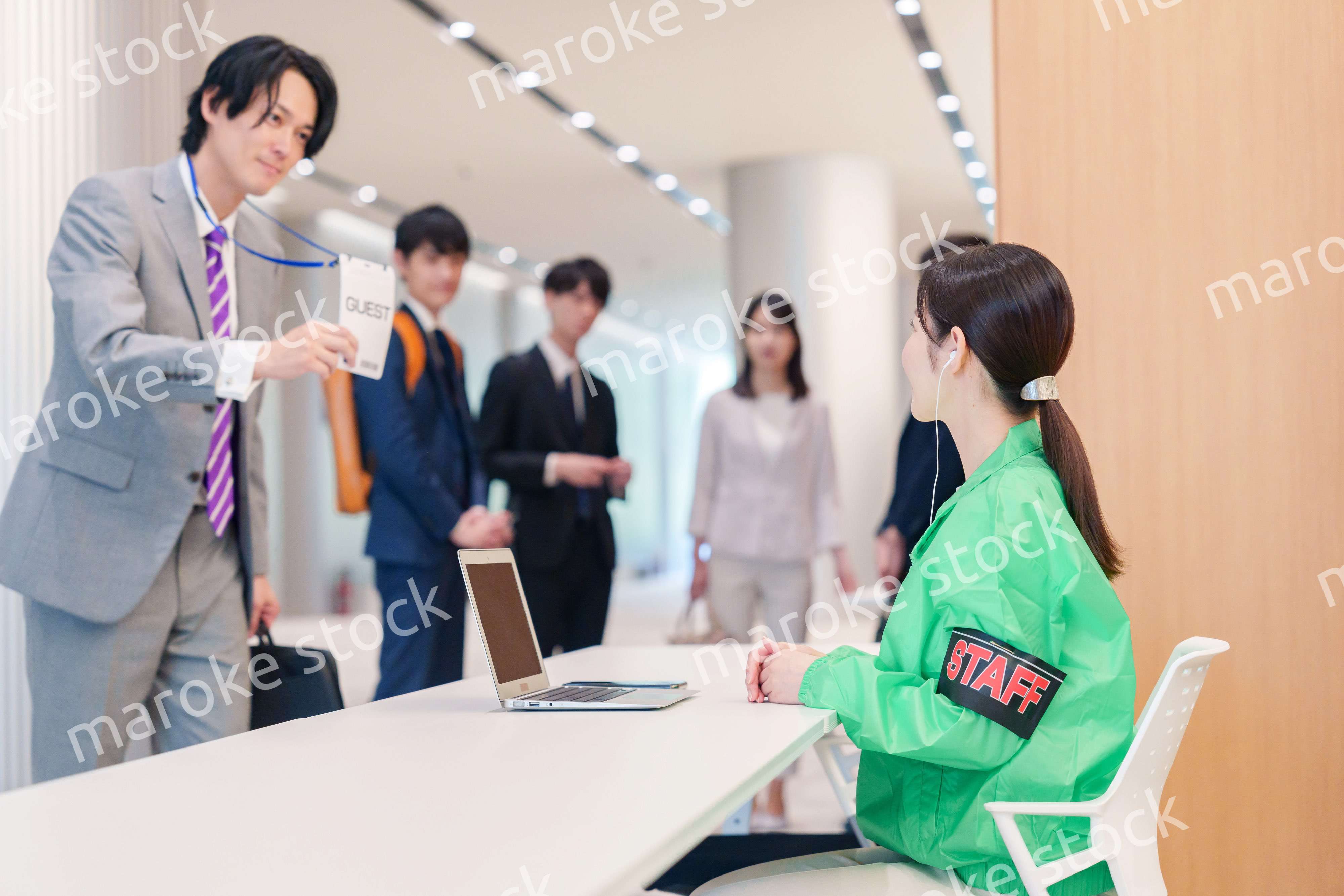 カンファレンスの受付スタッフと参加者