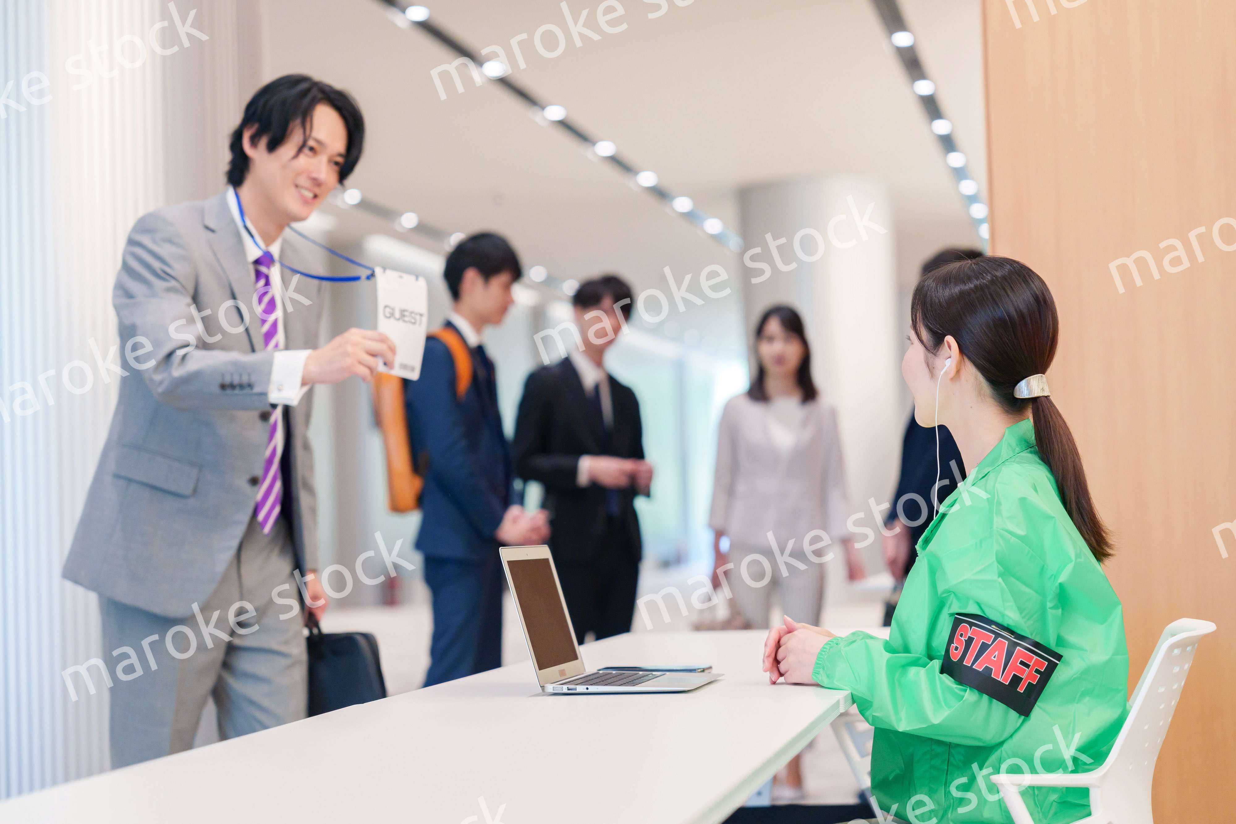 カンファレンスの受付スタッフと参加者