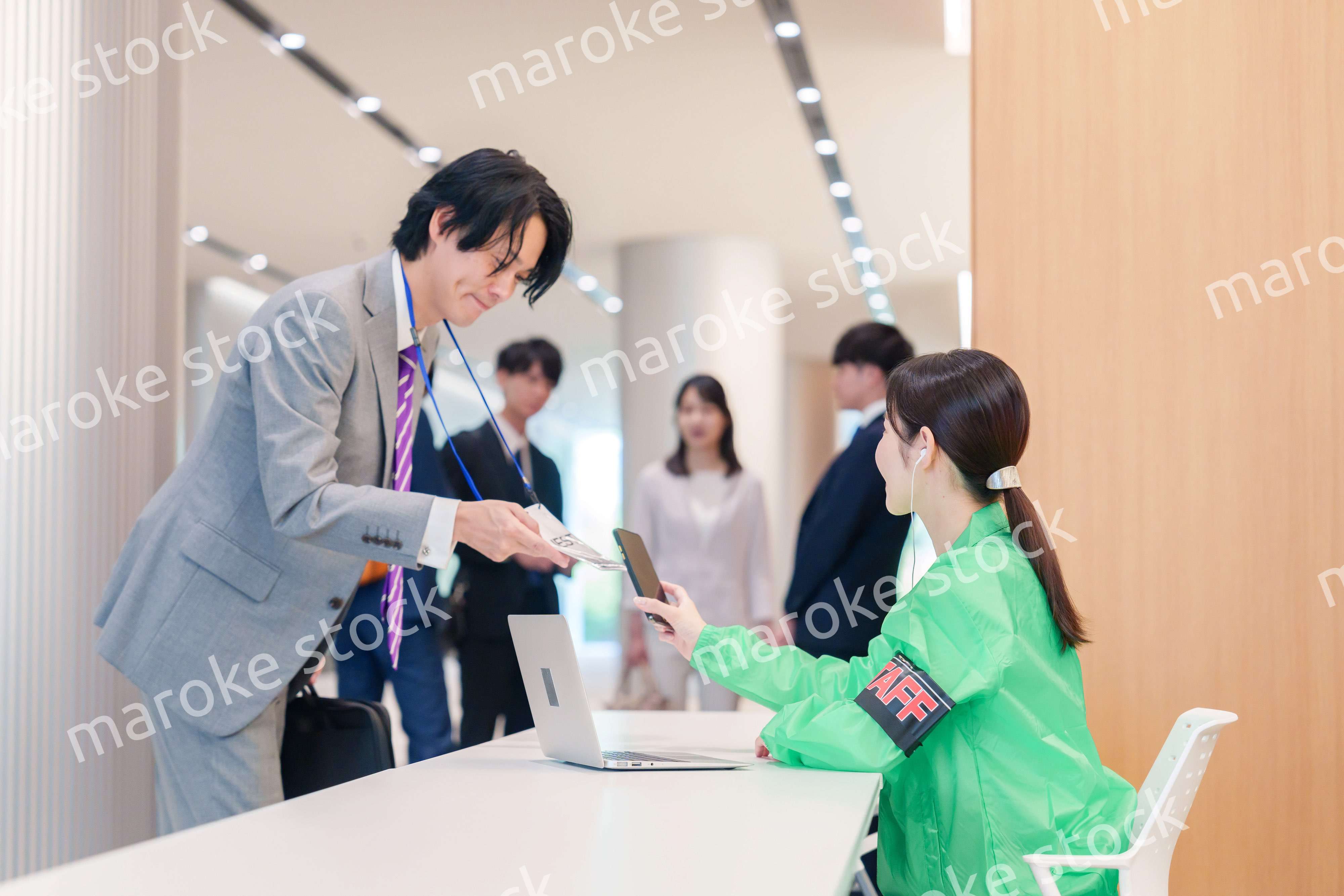 カンファレンスの受付スタッフと参加者