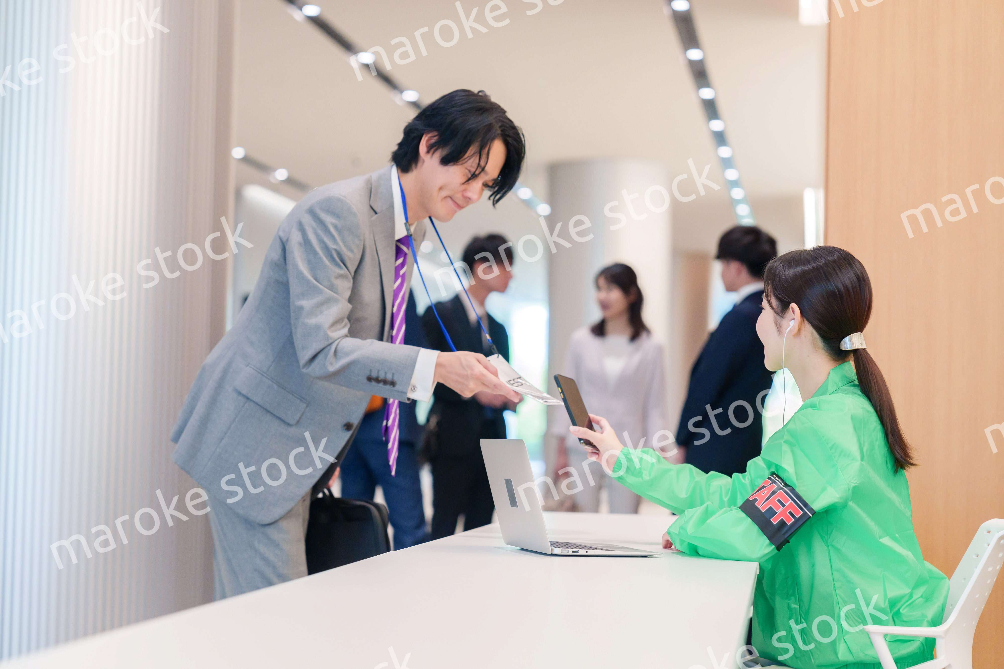 カンファレンスの受付スタッフと参加者