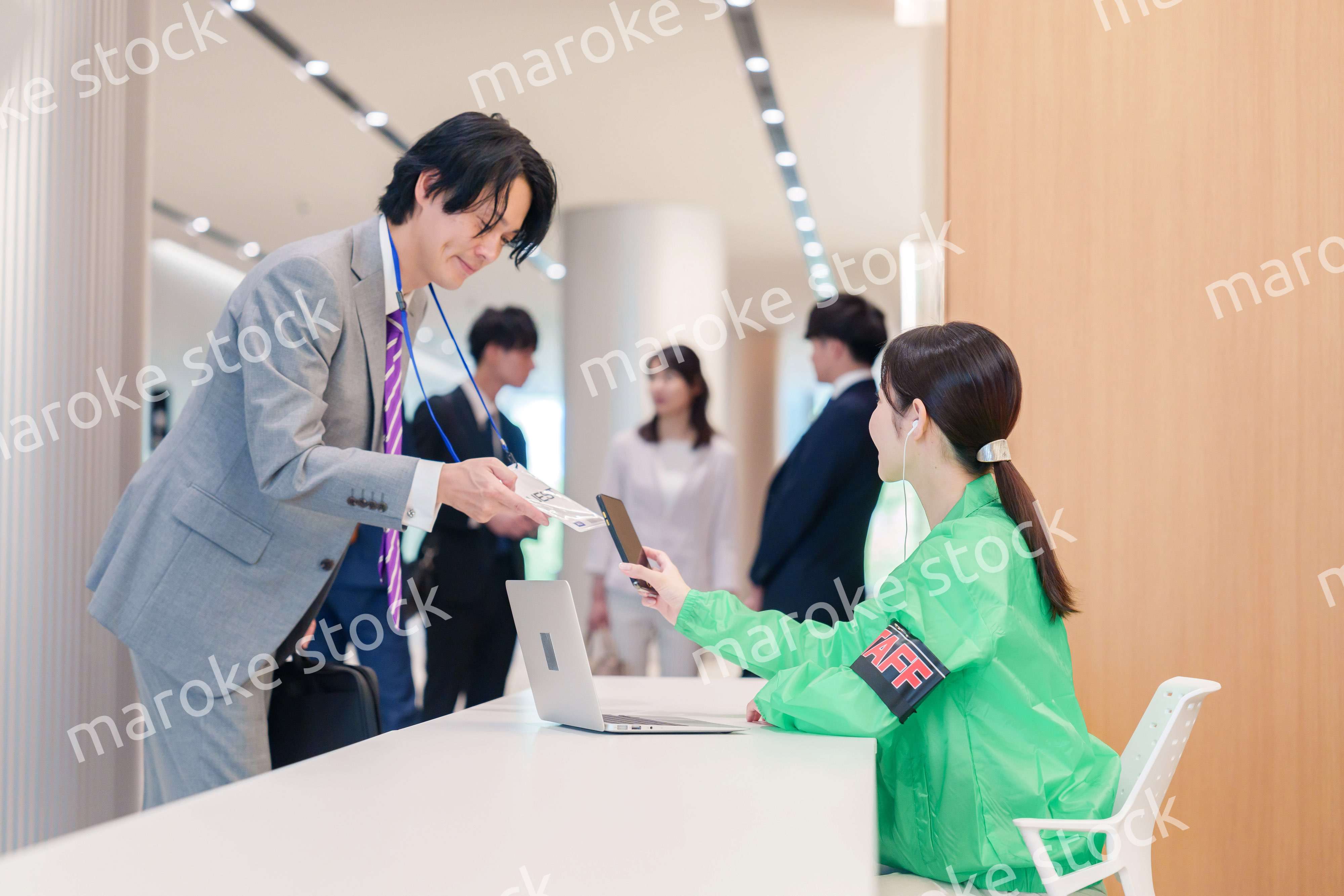 カンファレンスの受付スタッフと参加者