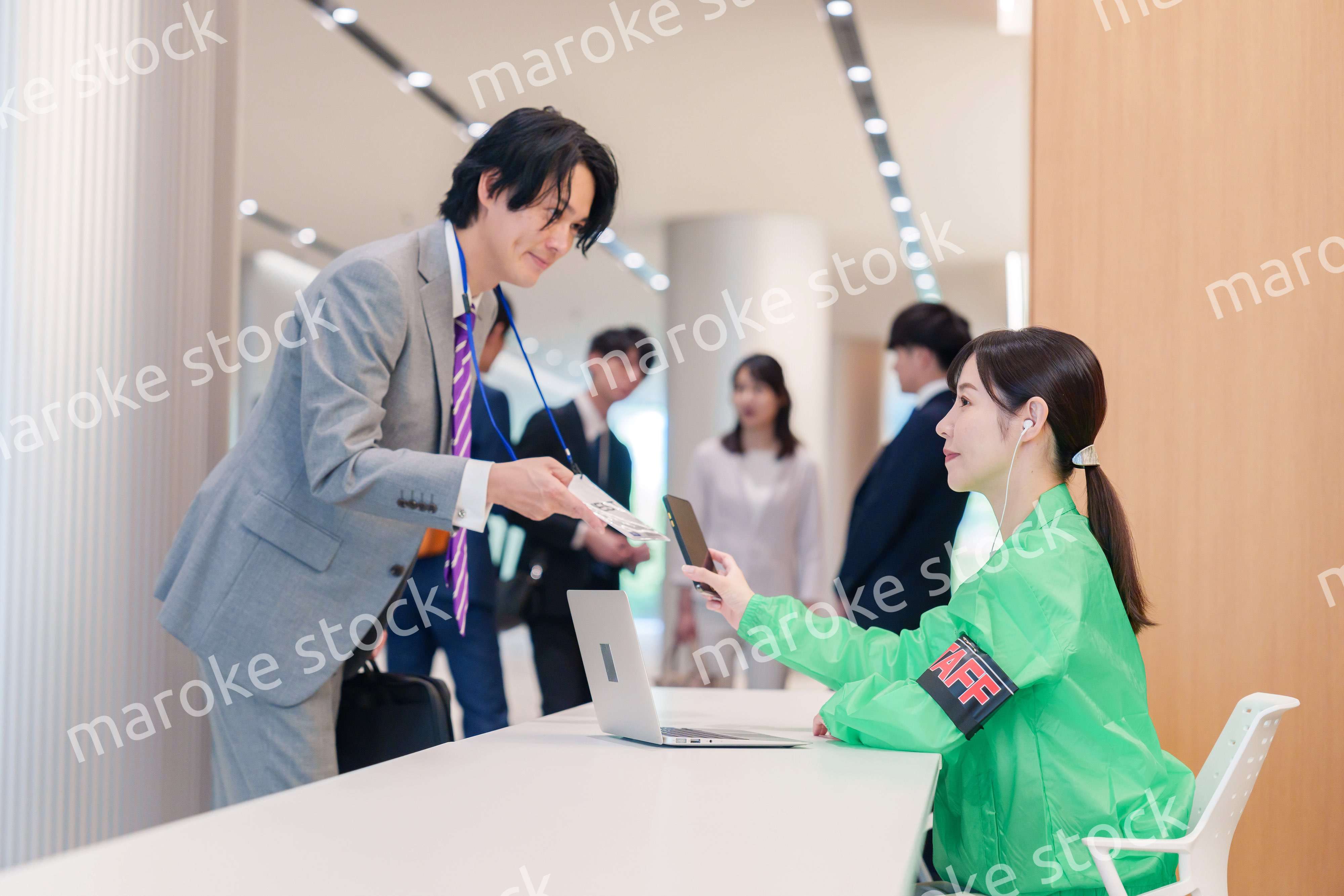 カンファレンスの受付スタッフと参加者