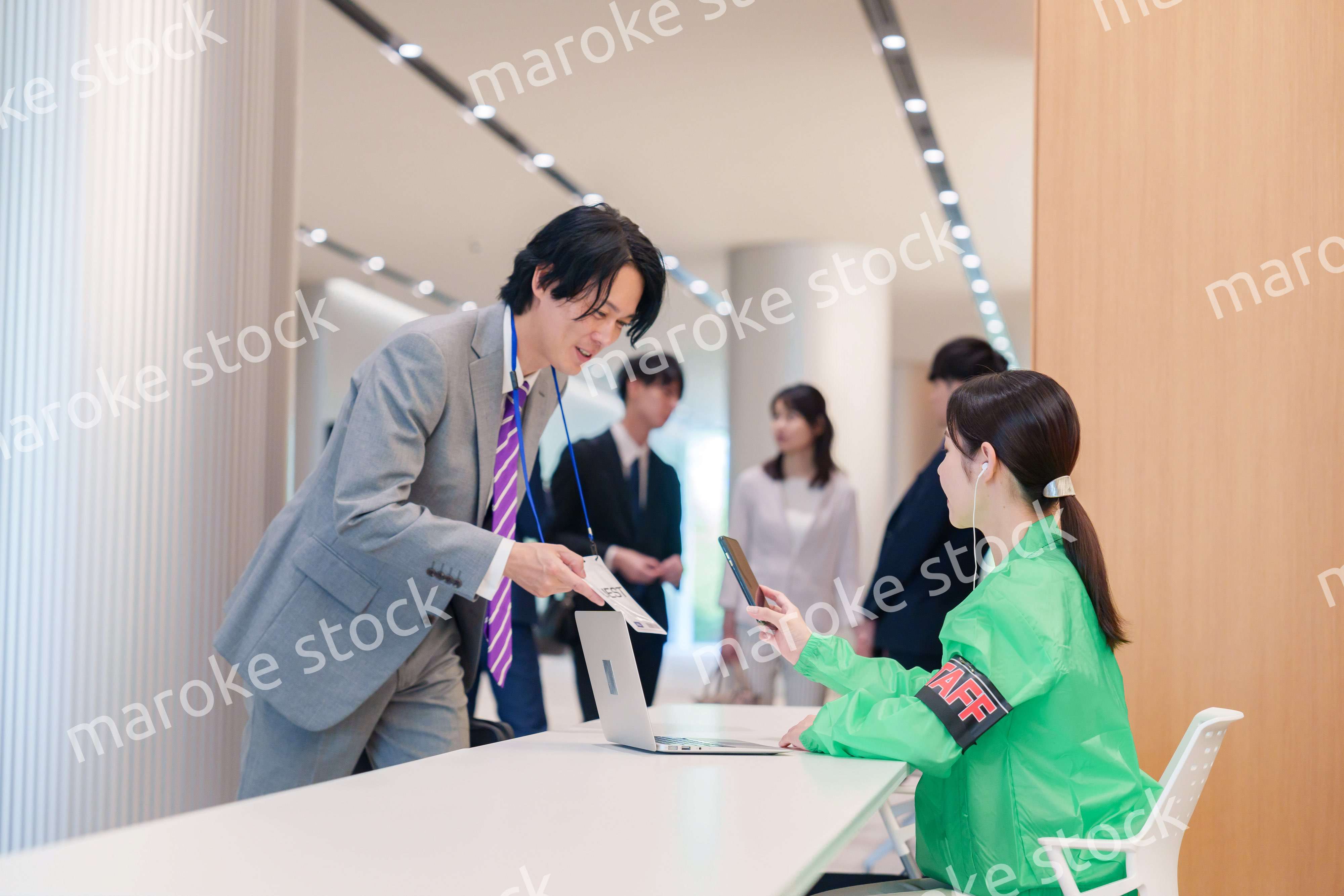 カンファレンスの受付スタッフと参加者