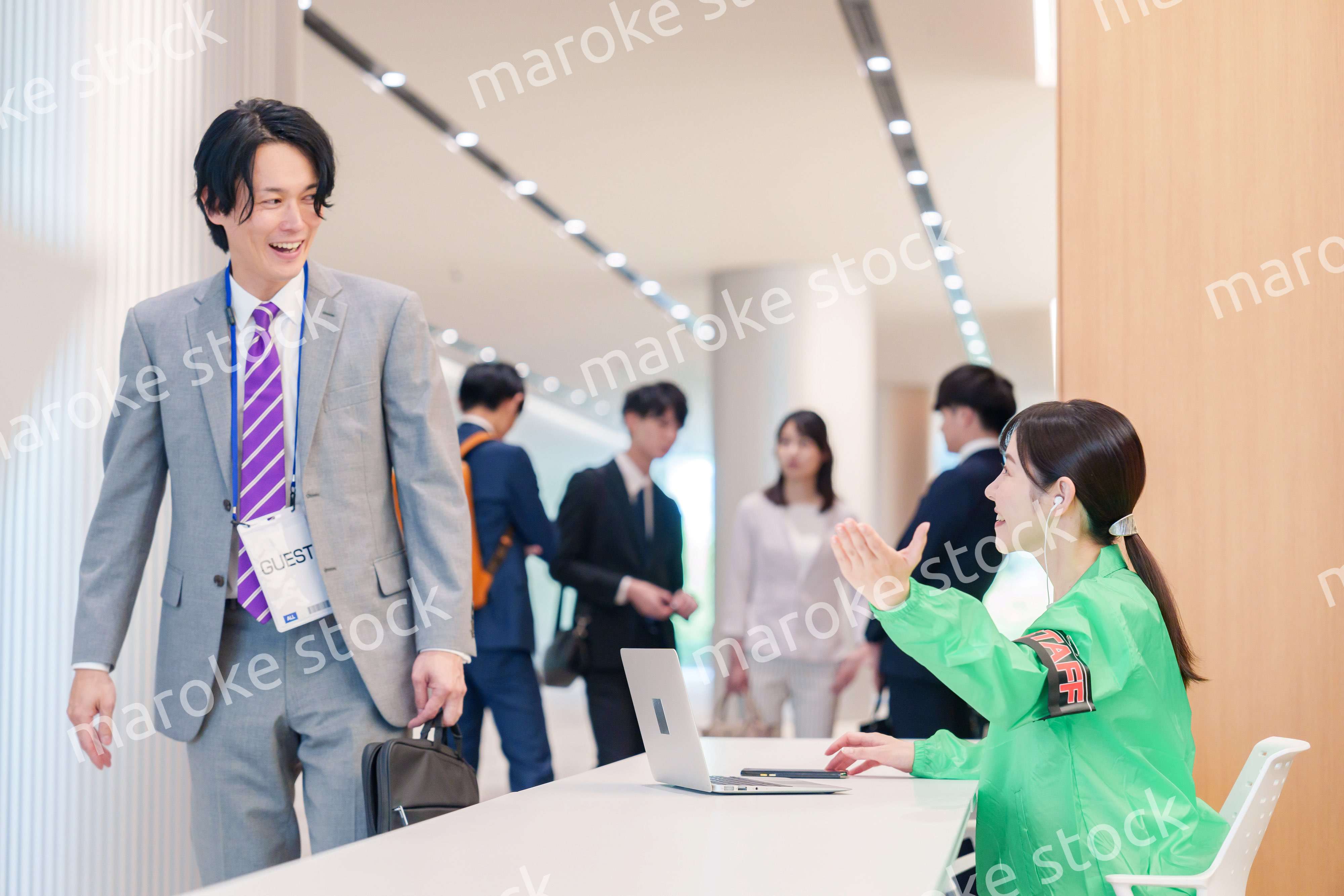 カンファレンスの受付スタッフと参加者