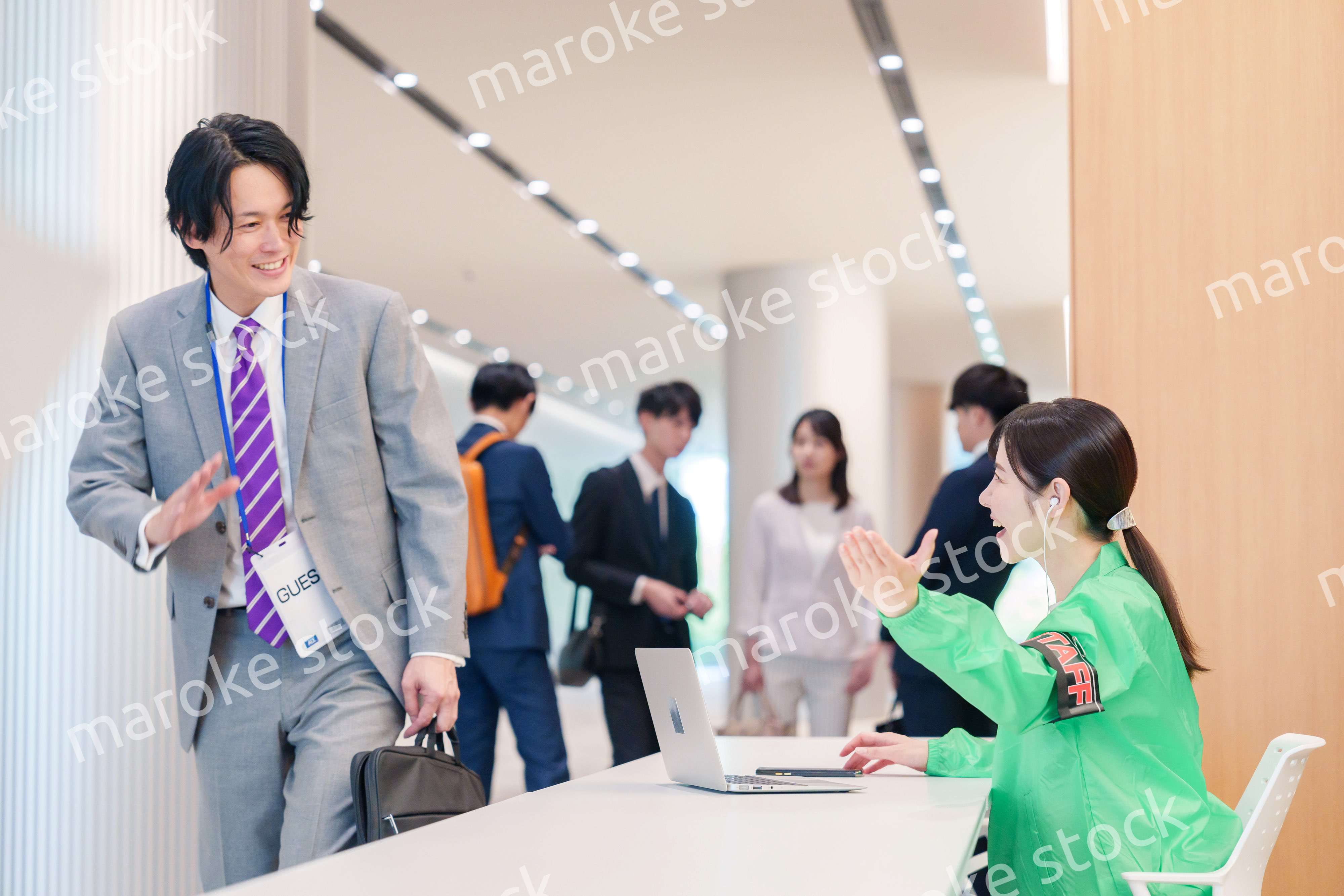 カンファレンスの受付スタッフと参加者