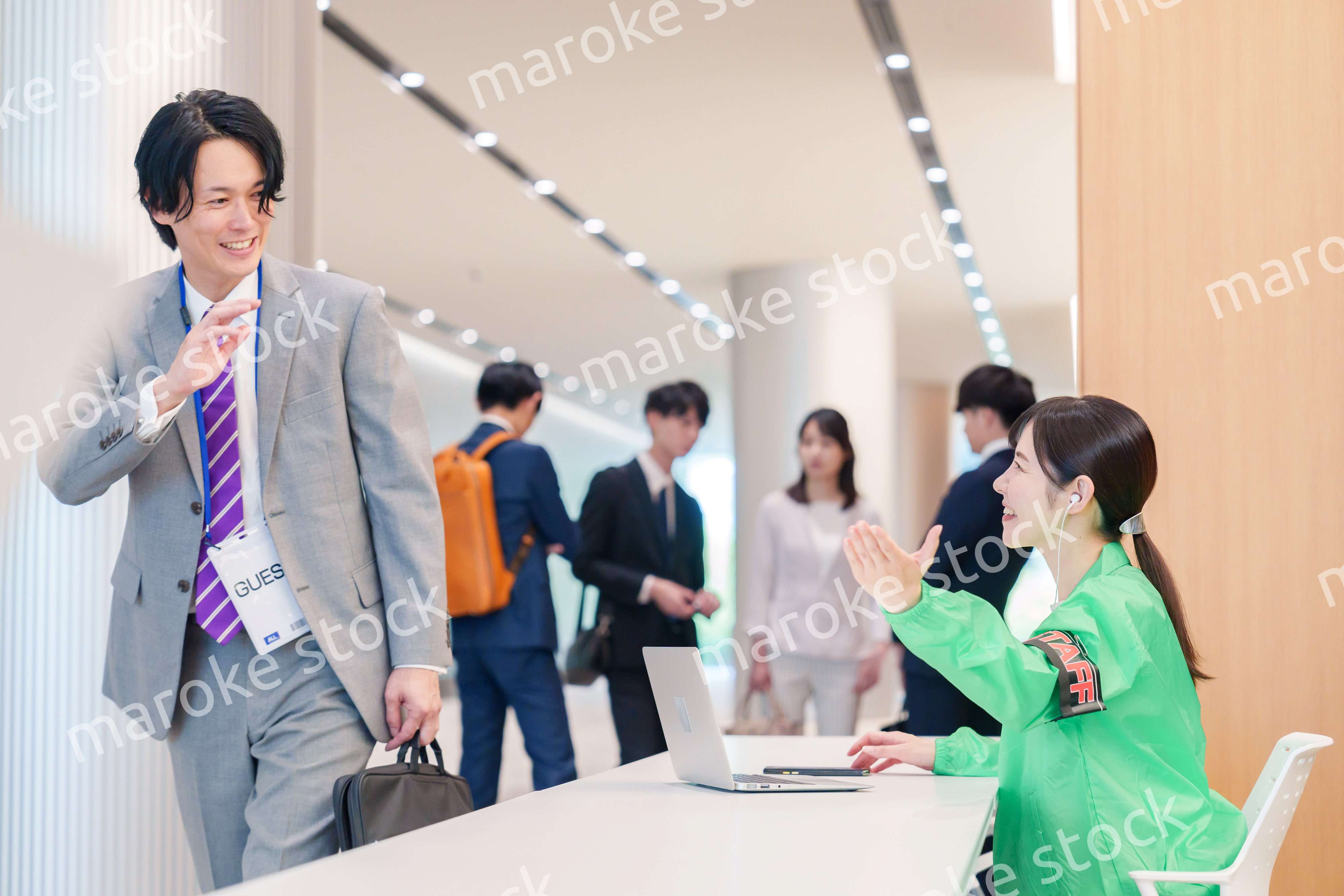 カンファレンスの受付スタッフと参加者