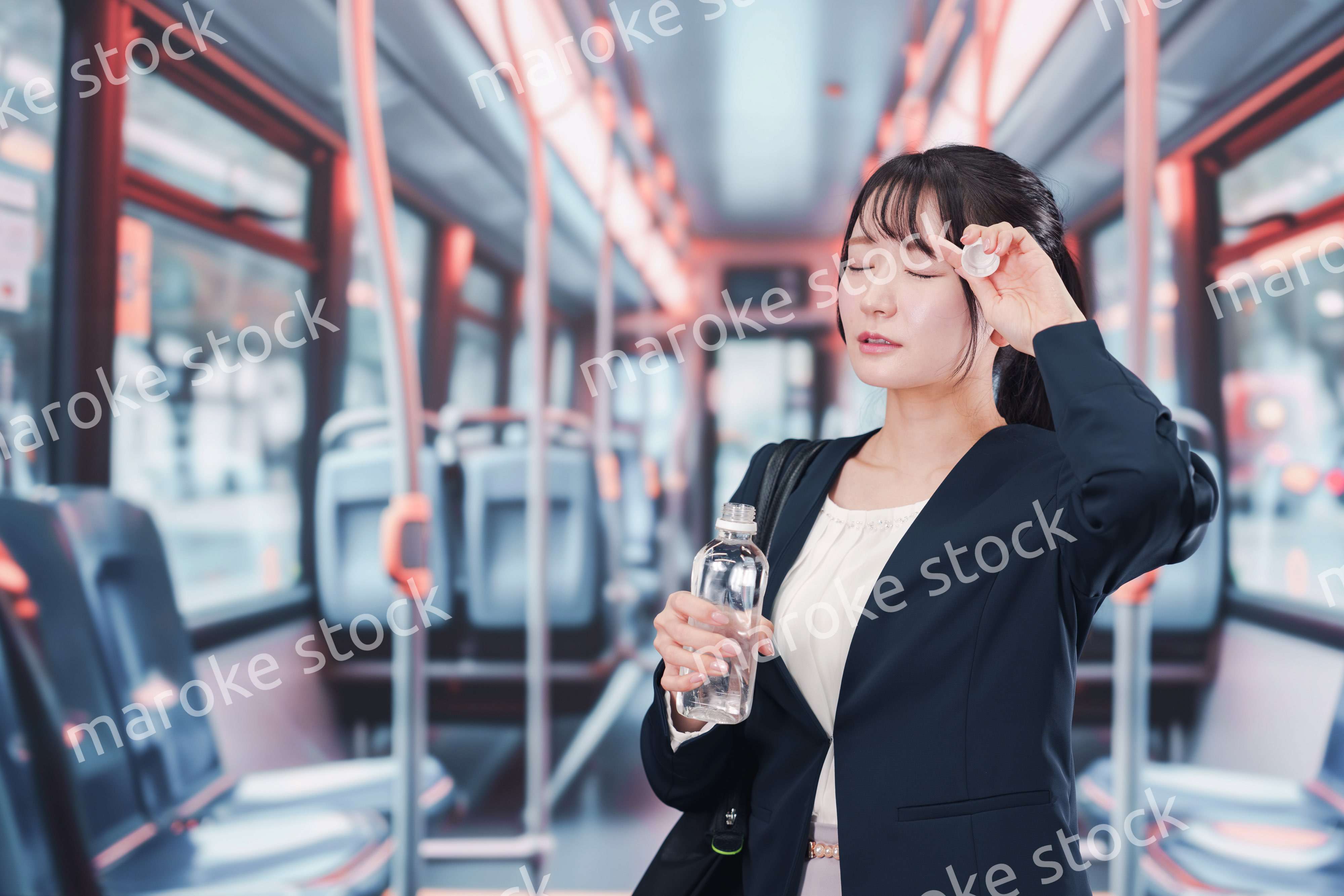 バスに乗って通勤をする若い女性