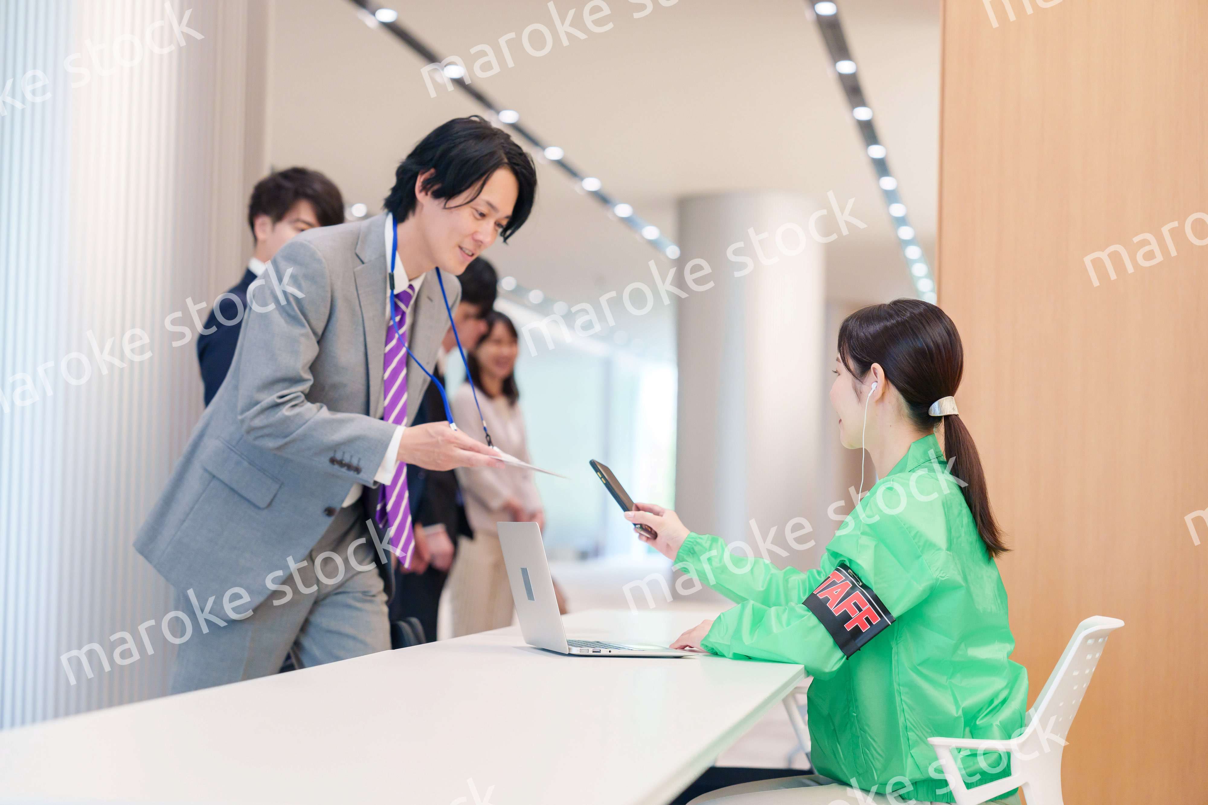 カンファレンスの受付スタッフと参加者