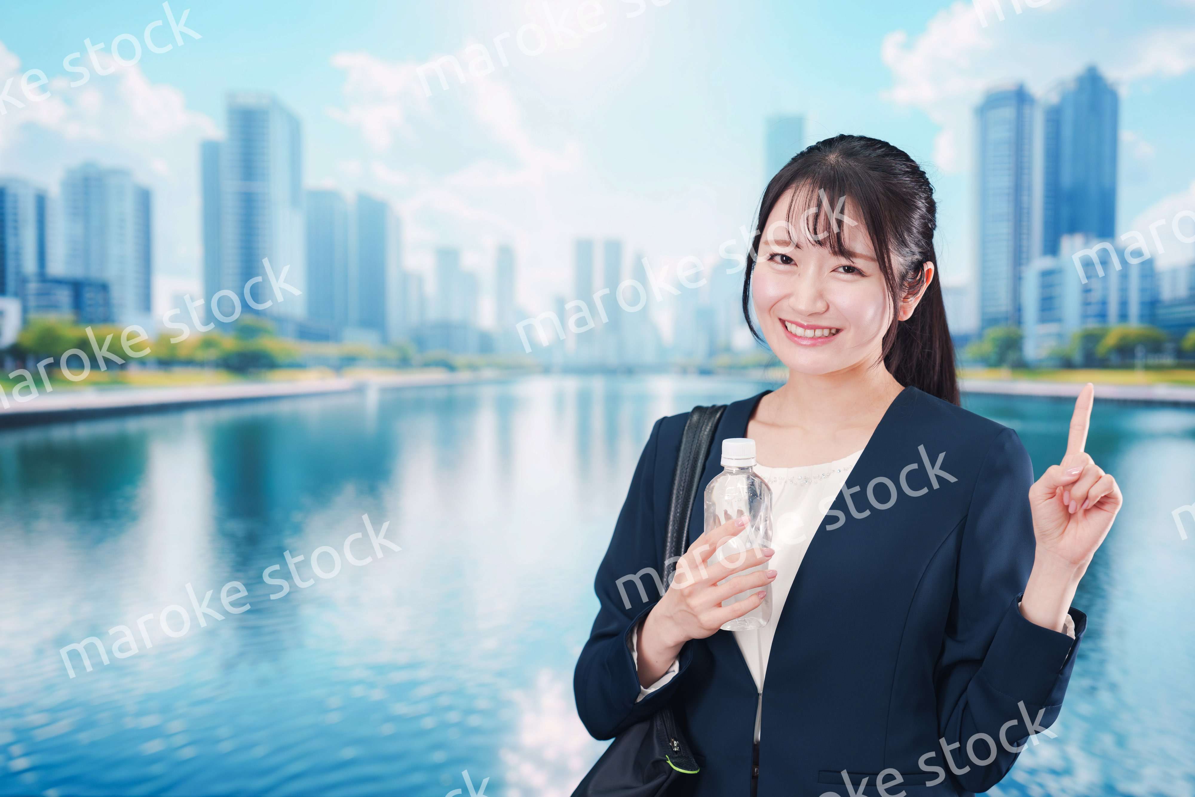 ペットボトルを持って笑顔で通勤をする若い女性