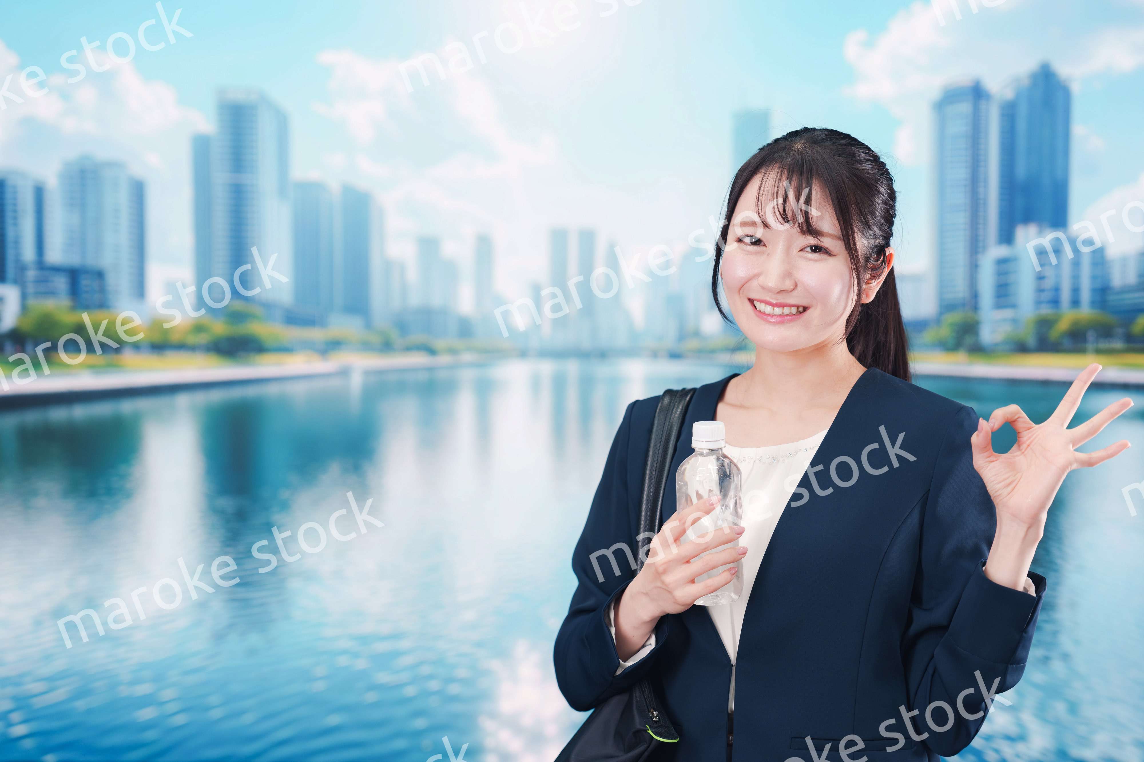 ペットボトルを持って笑顔で通勤をする若い女性