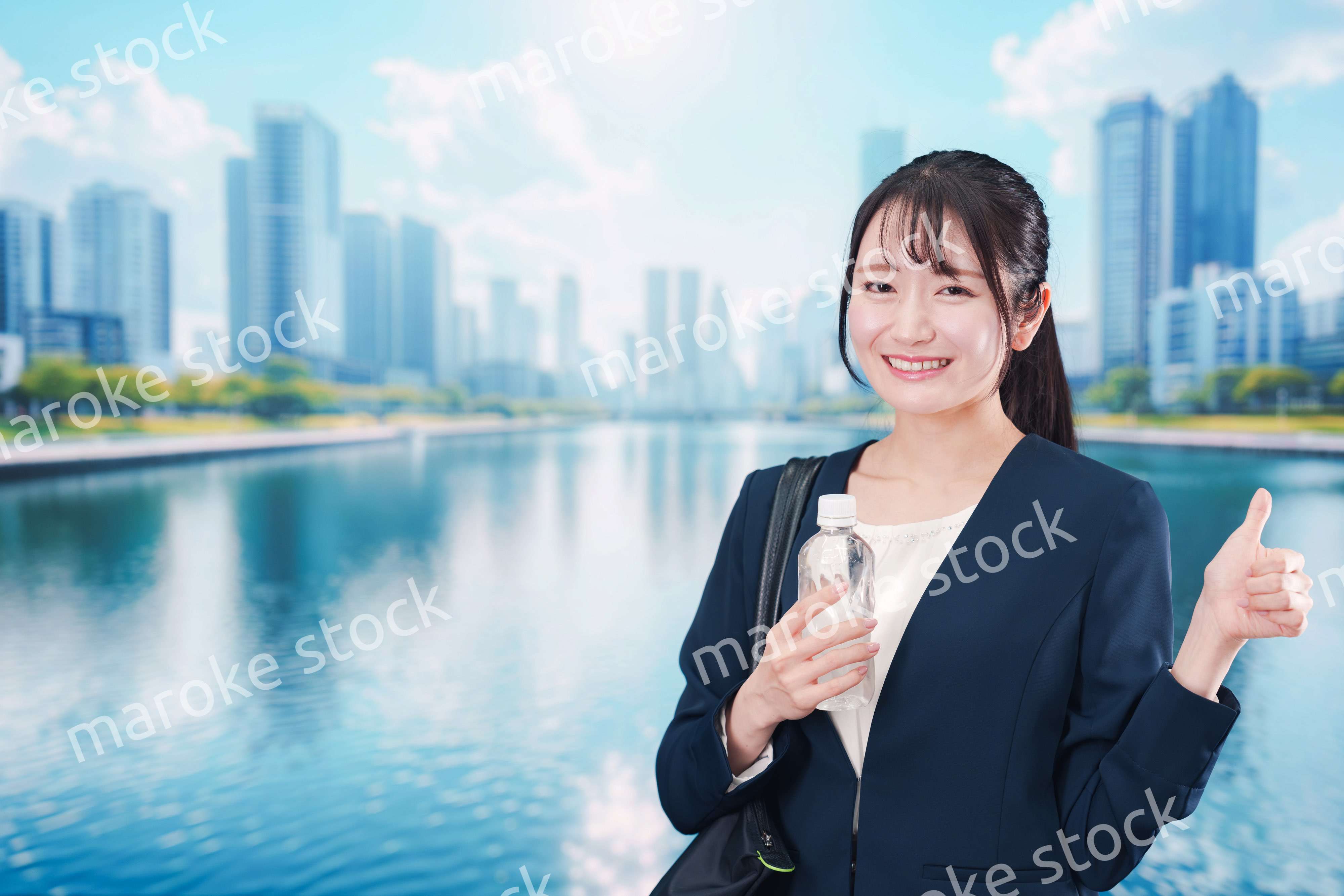 ペットボトルを持って笑顔で通勤をする若い女性