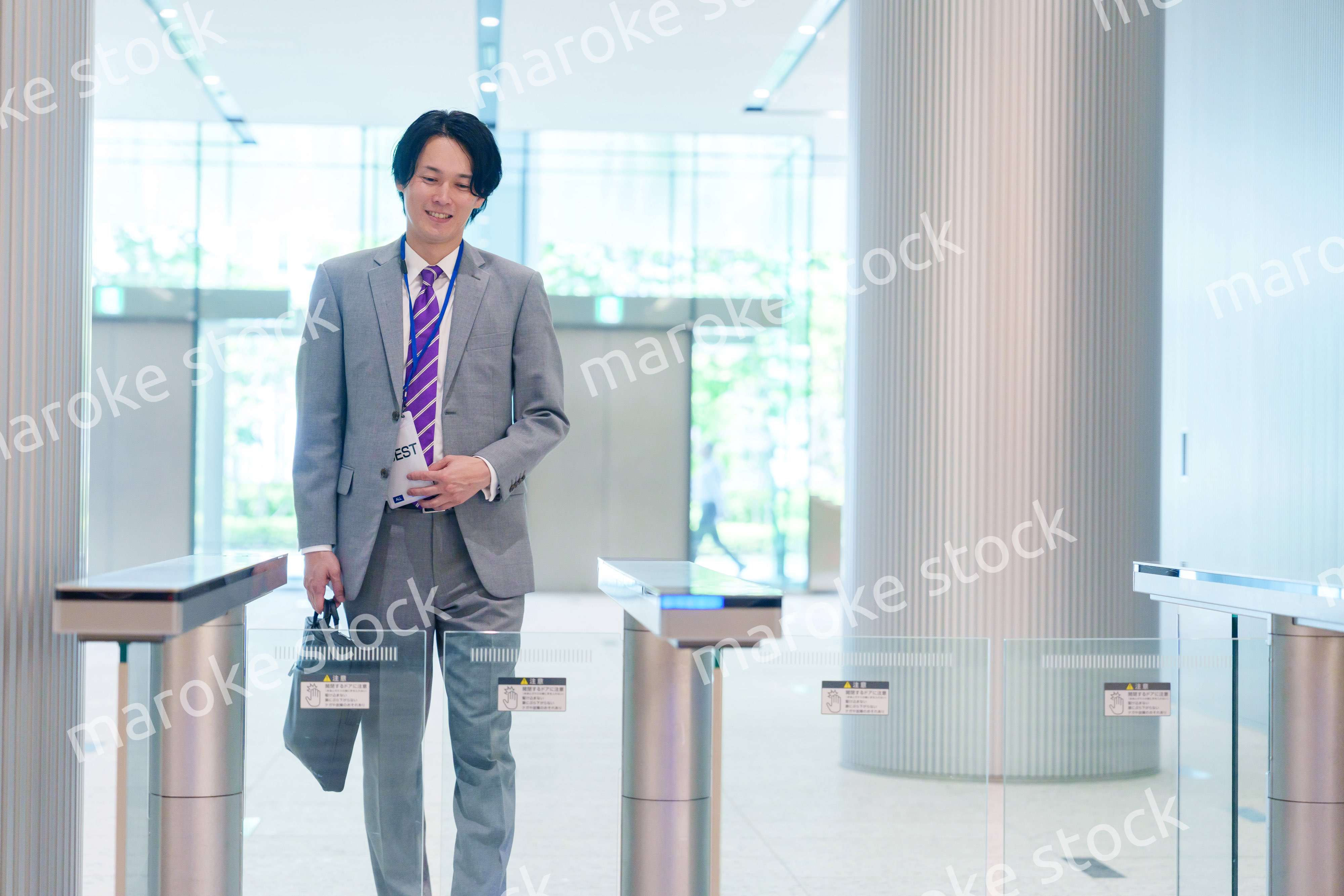 ゲストバッジをつけてビルに入館するビジネスマン