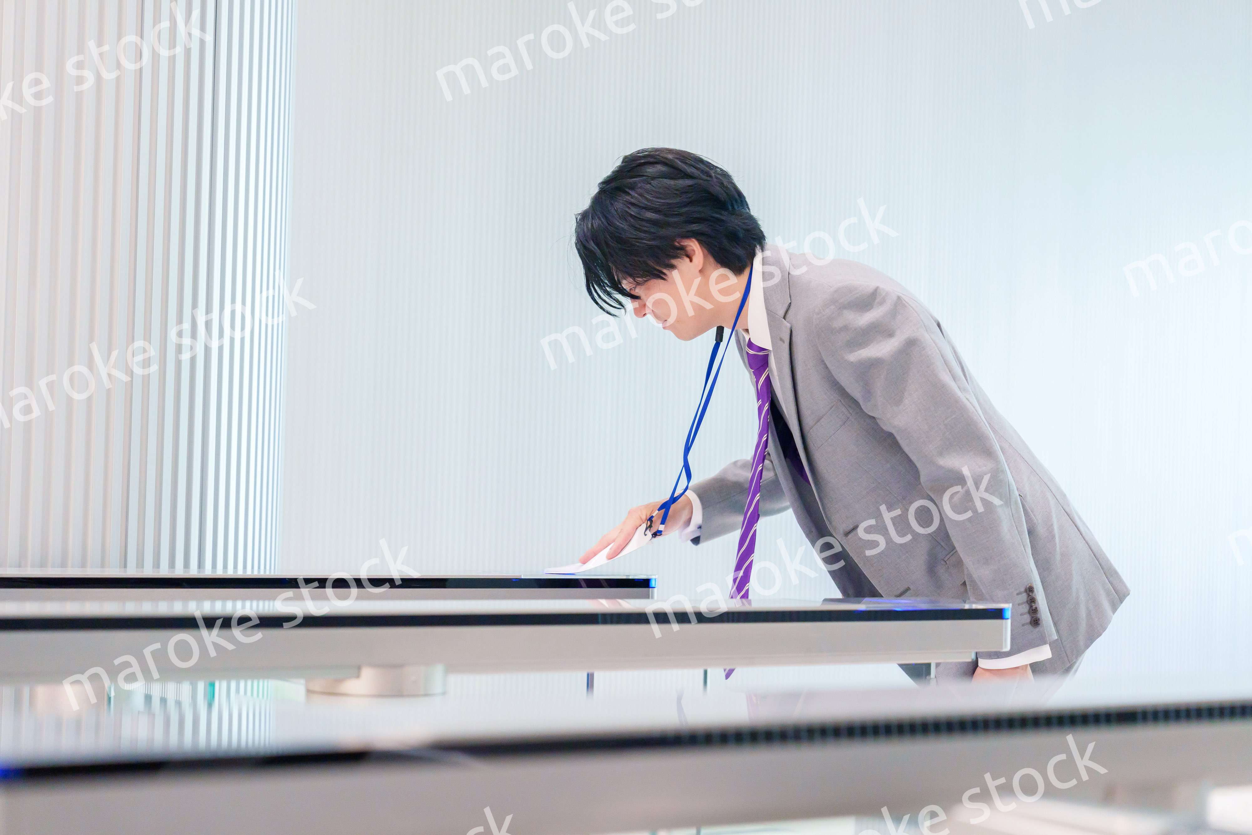 ゲストバッジをつけてビルに入館するビジネスマン