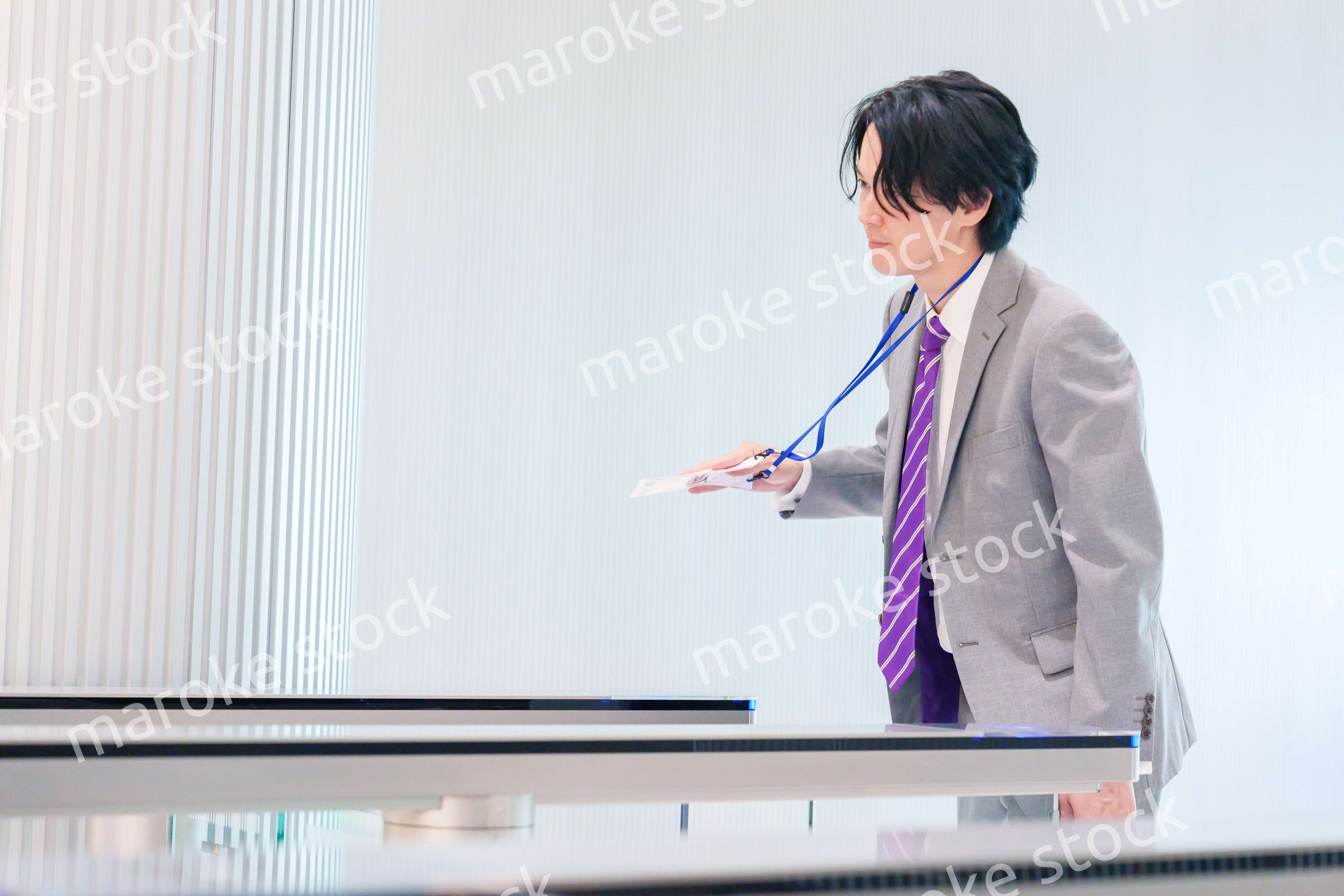 ゲストバッジをつけてビルに入館するビジネスマン