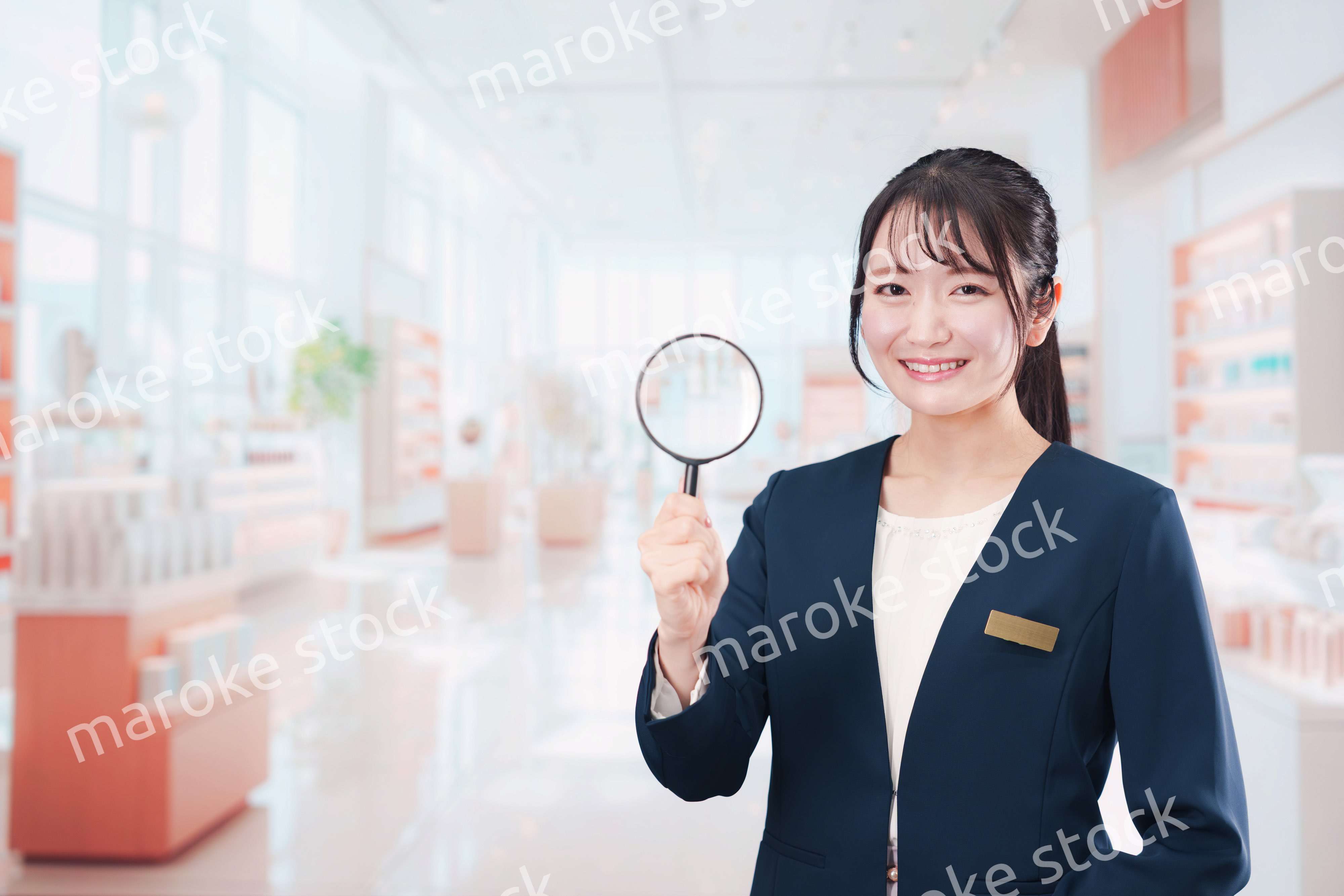 笑顔でルーペを持つ美容部員の女性