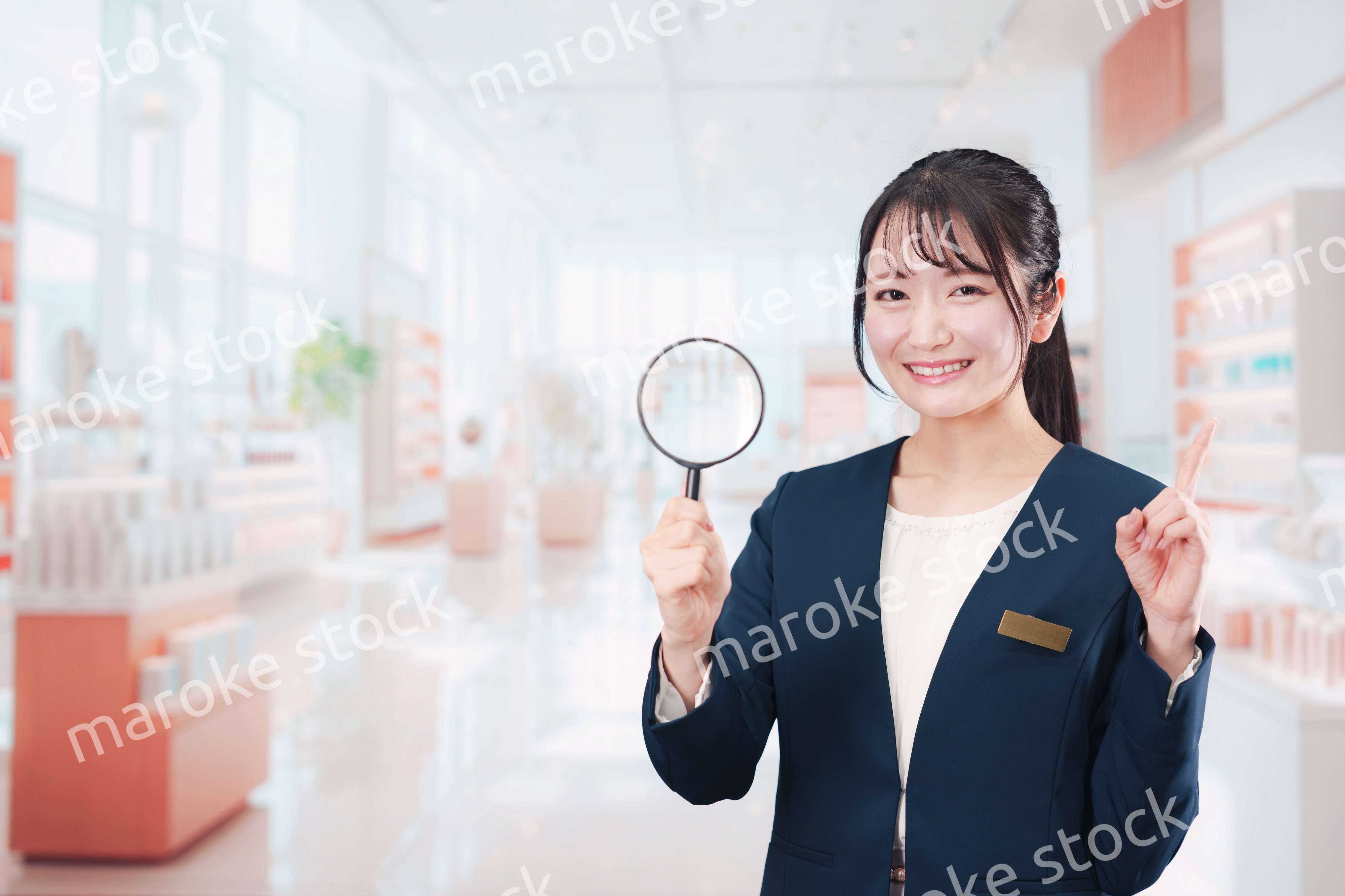 笑顔でルーペを持つ美容部員の女性