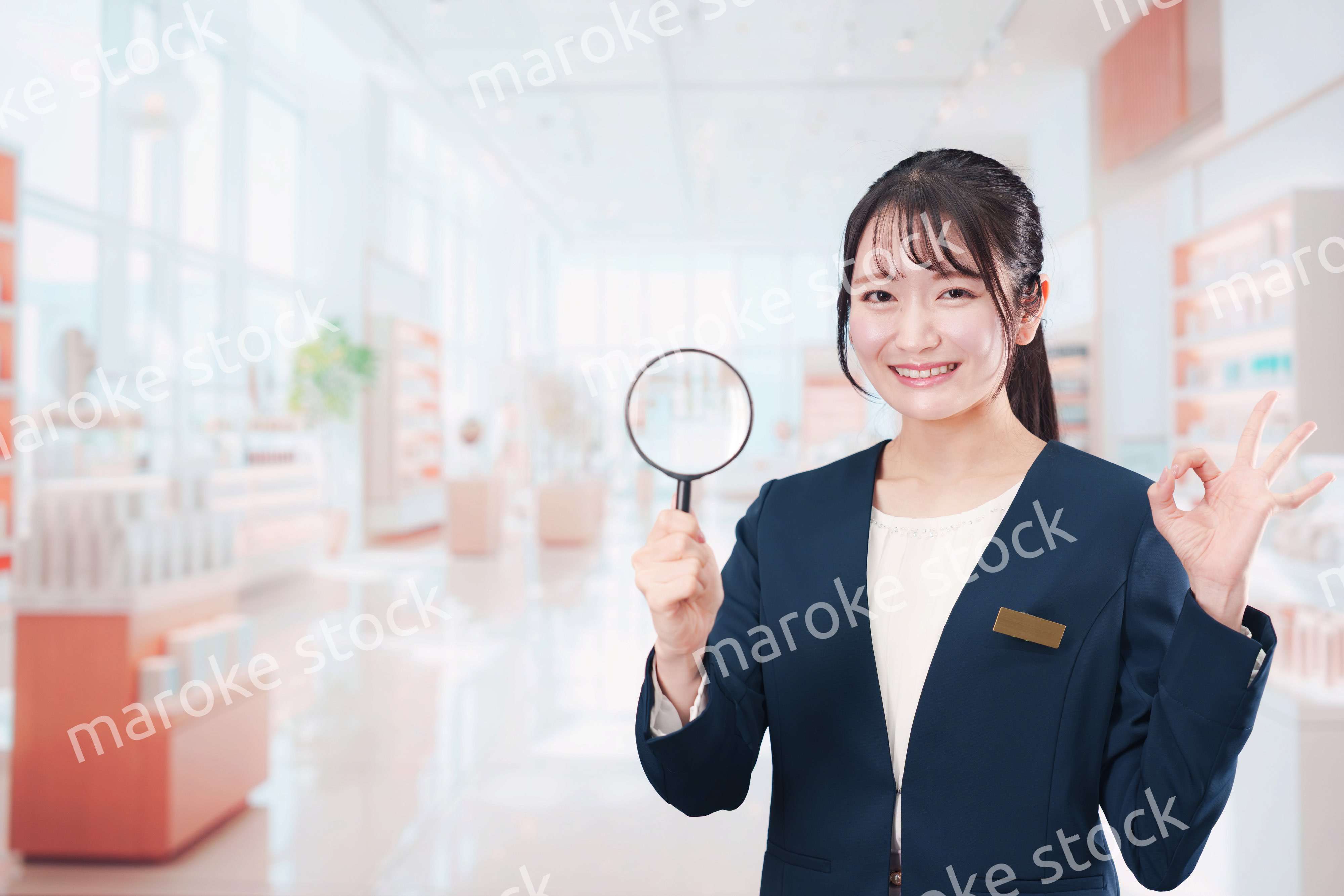 笑顔でルーペを持つ美容部員の女性