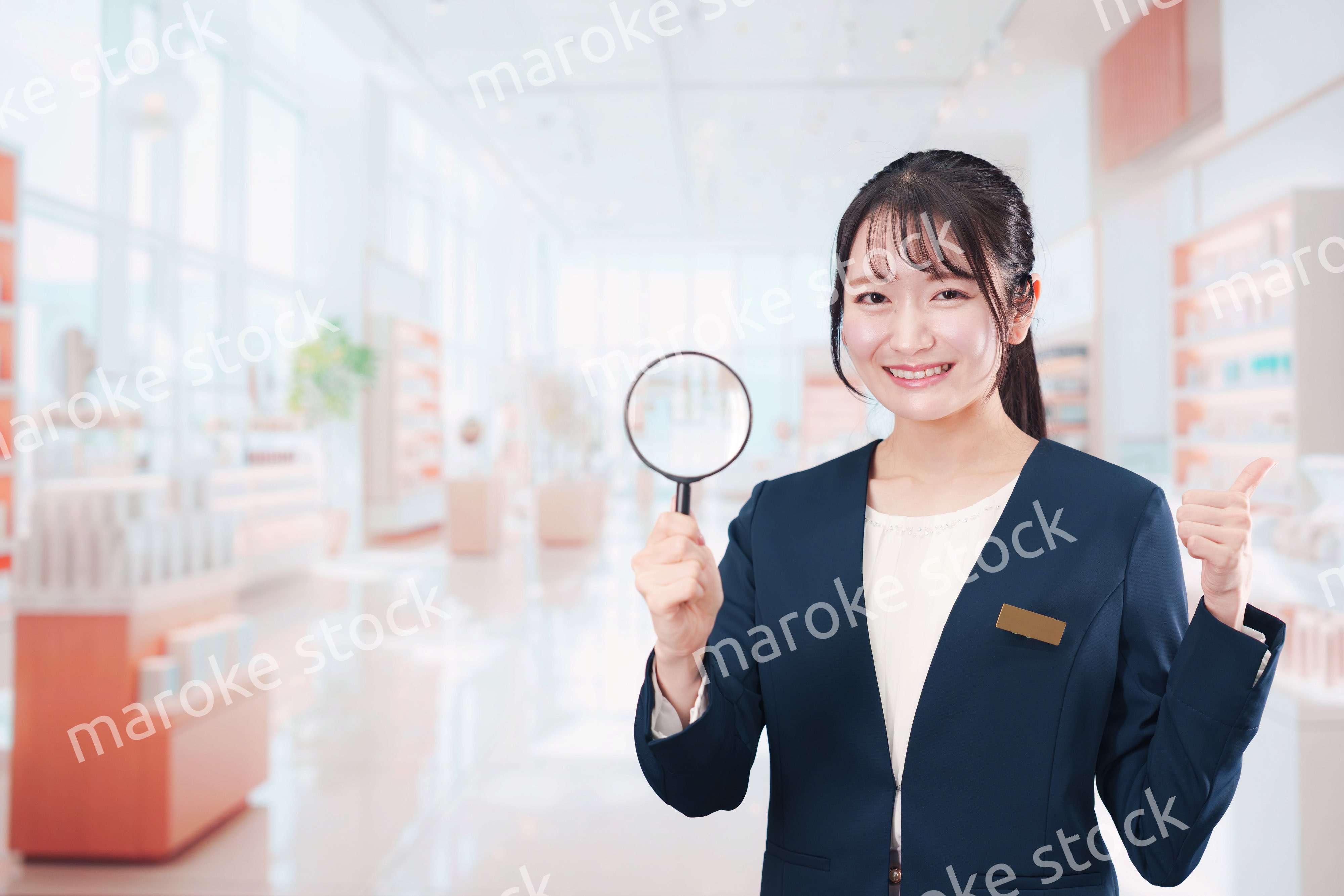 笑顔でルーペを持つ美容部員の女性