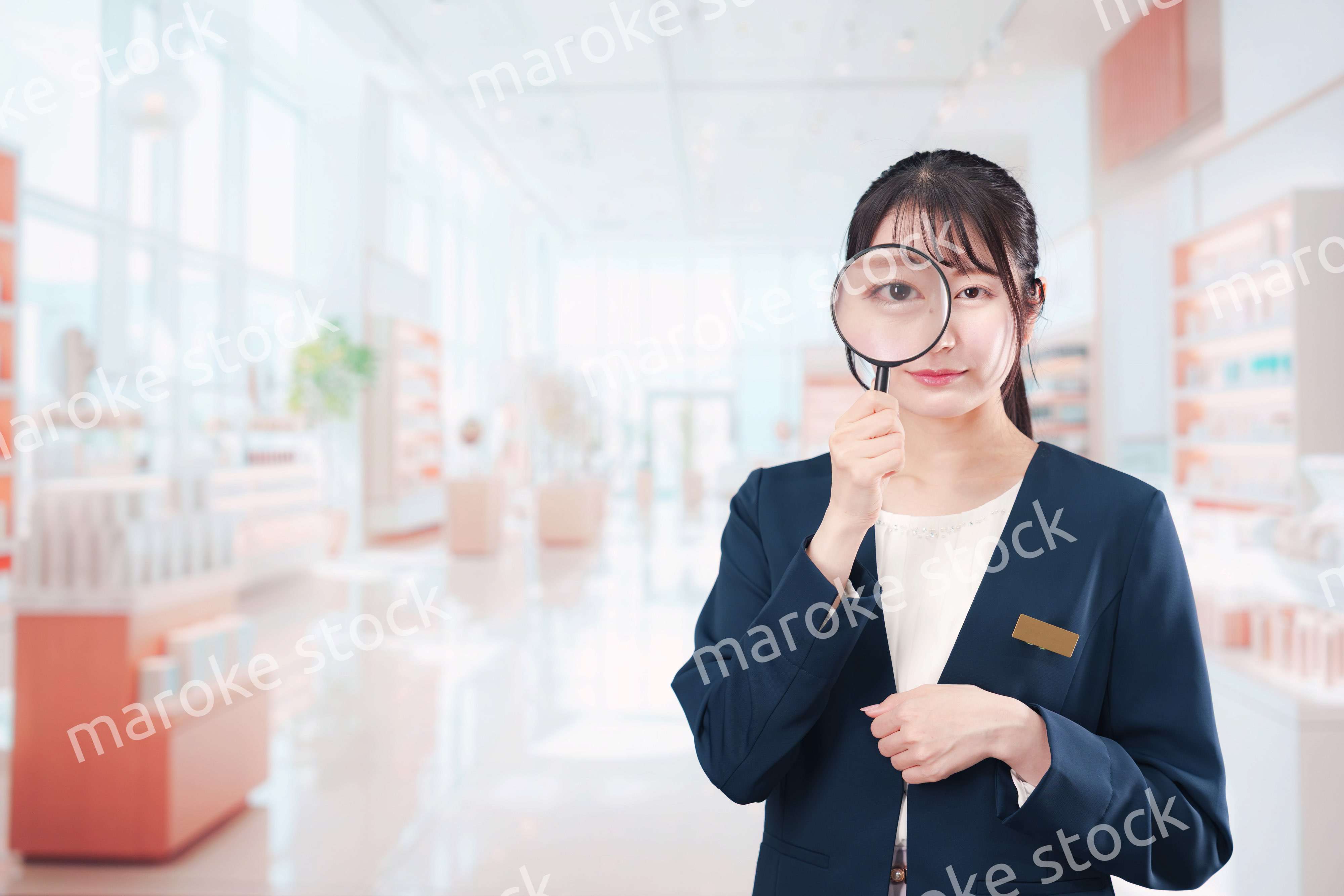 笑顔でルーペを持つ美容部員の女性