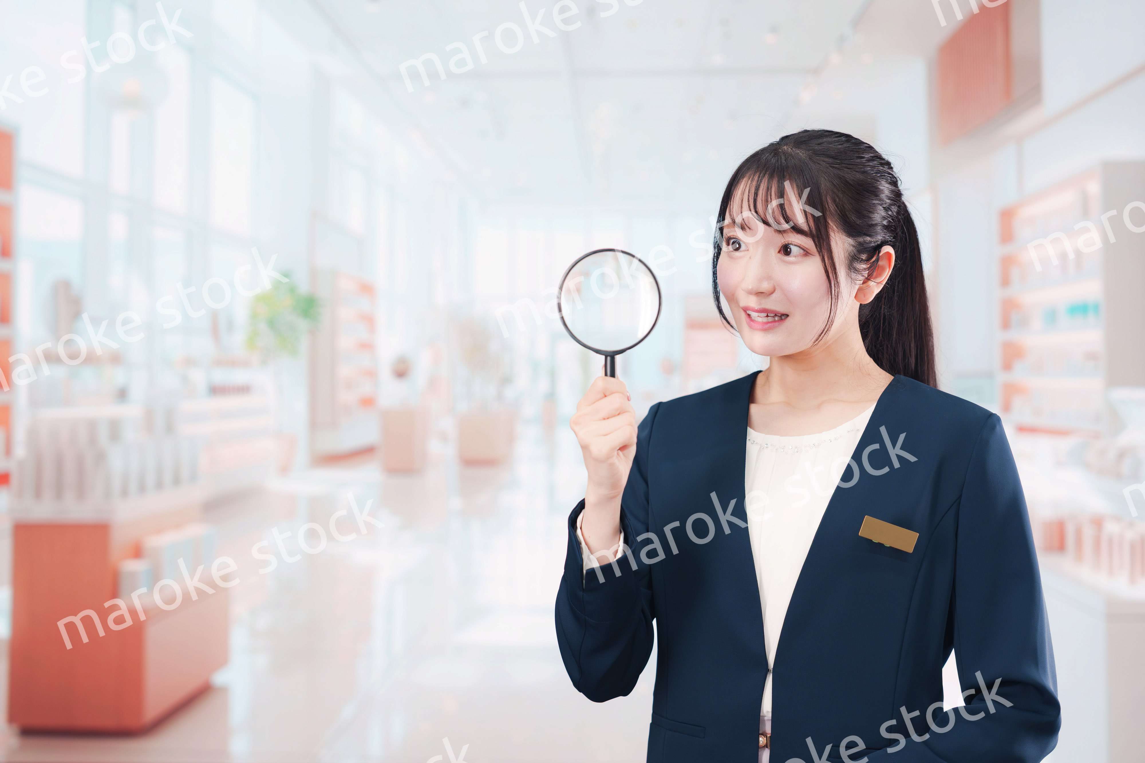 笑顔でルーペを持つ美容部員の女性