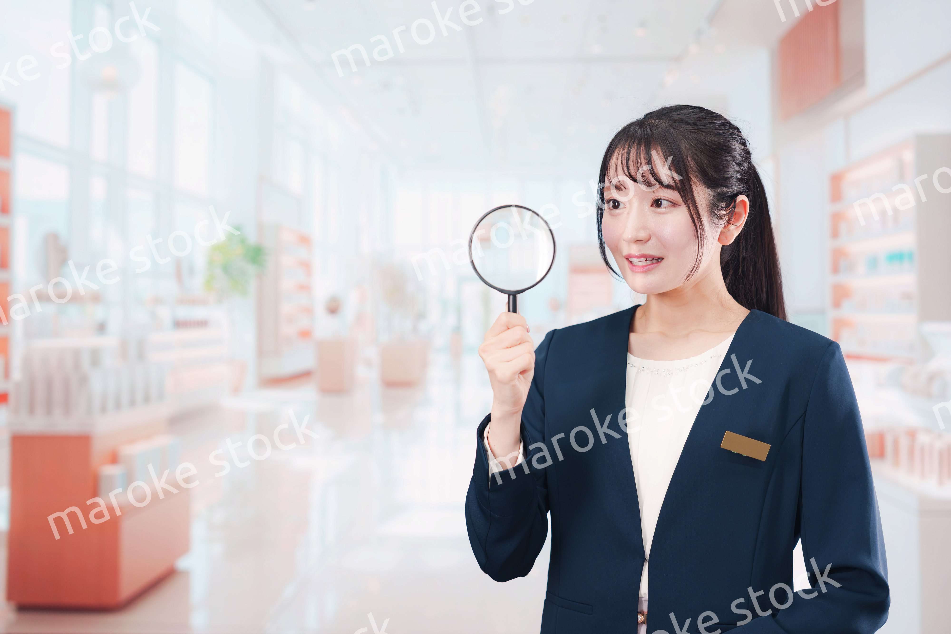 笑顔でルーペを持つ美容部員の女性