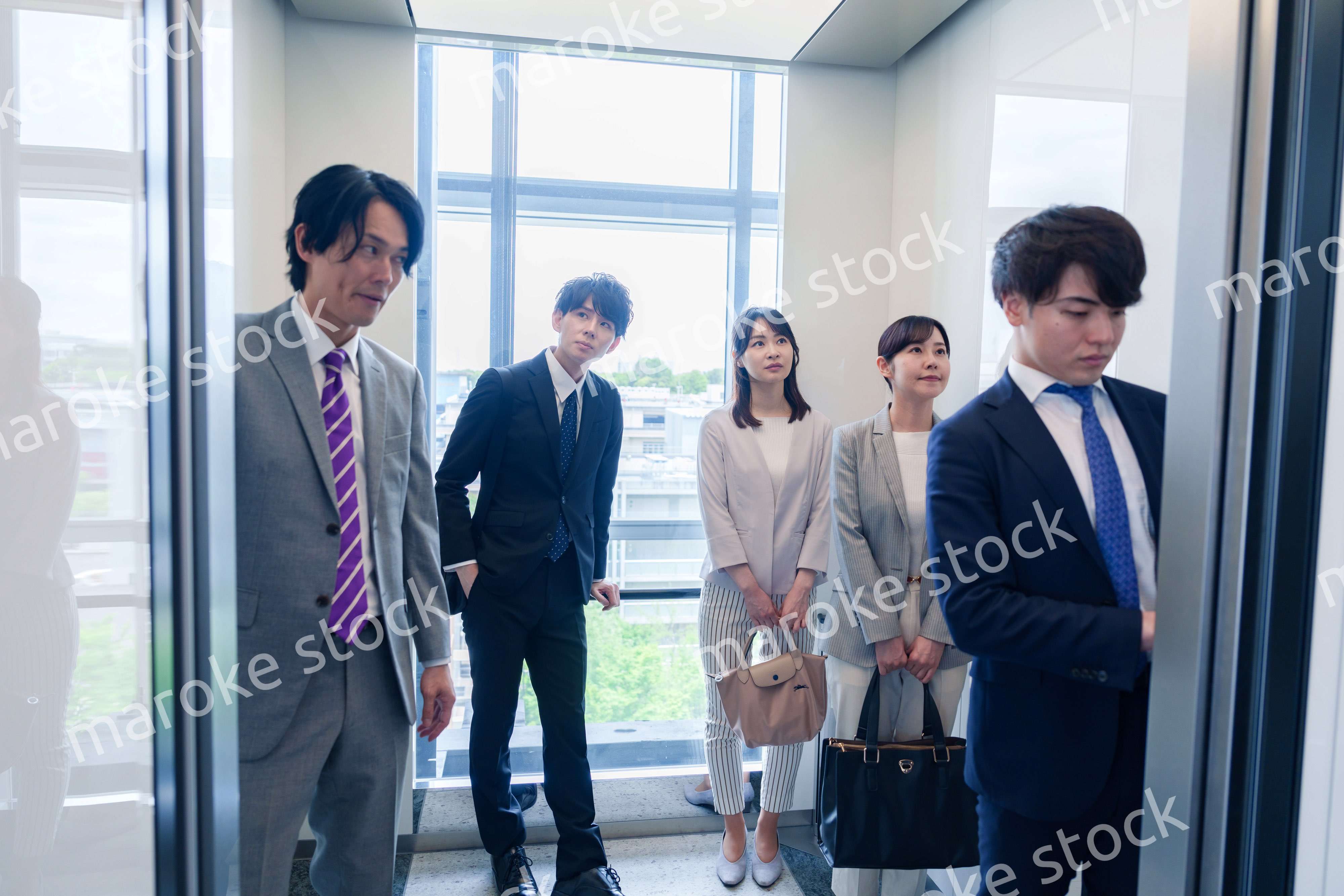 オフィスでエレベーターに乗るビジネスパーソン