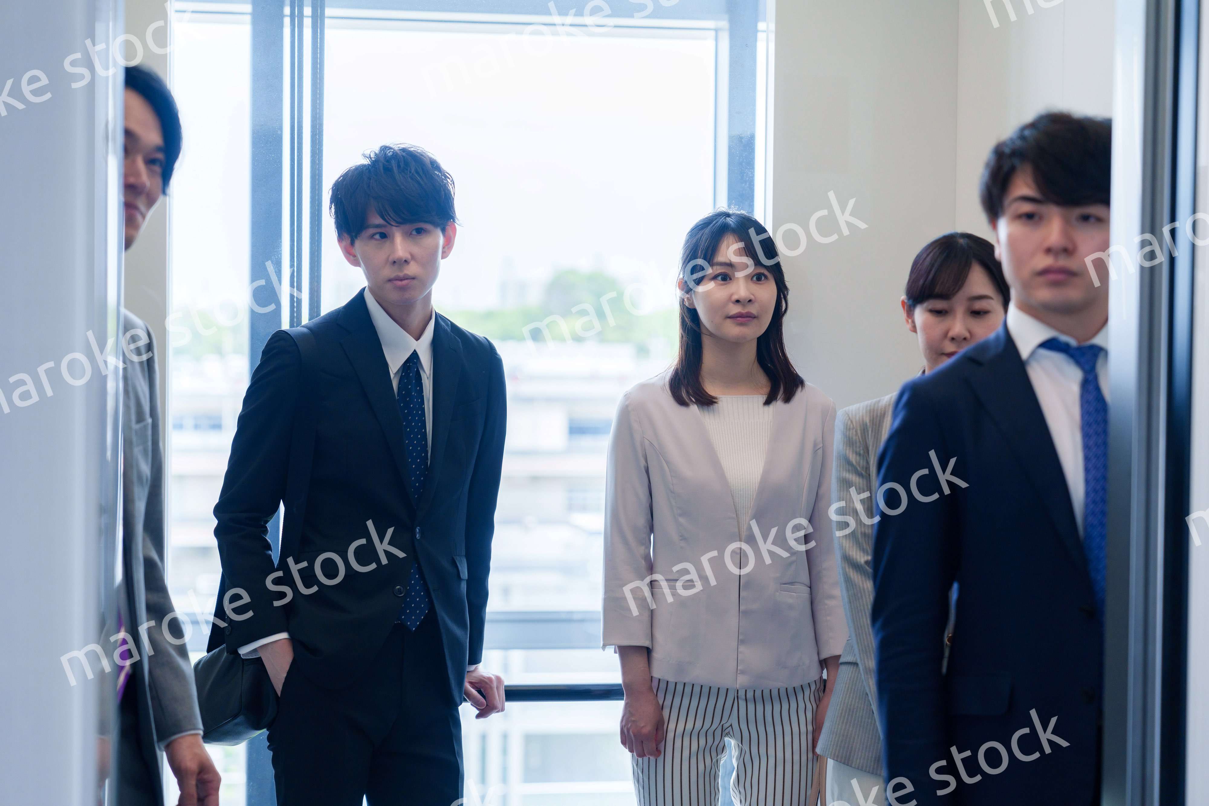 オフィスでエレベーターに乗るビジネスパーソン