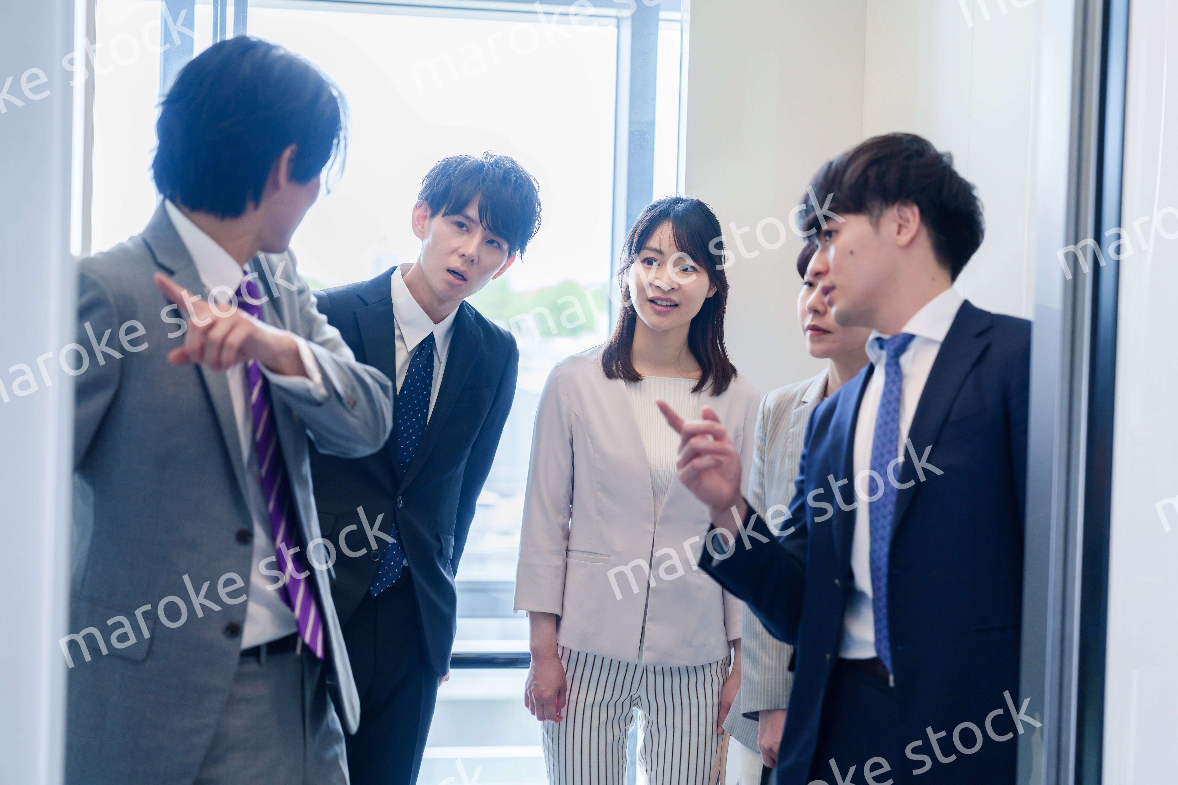 オフィスでエレベーターに乗るビジネスパーソン