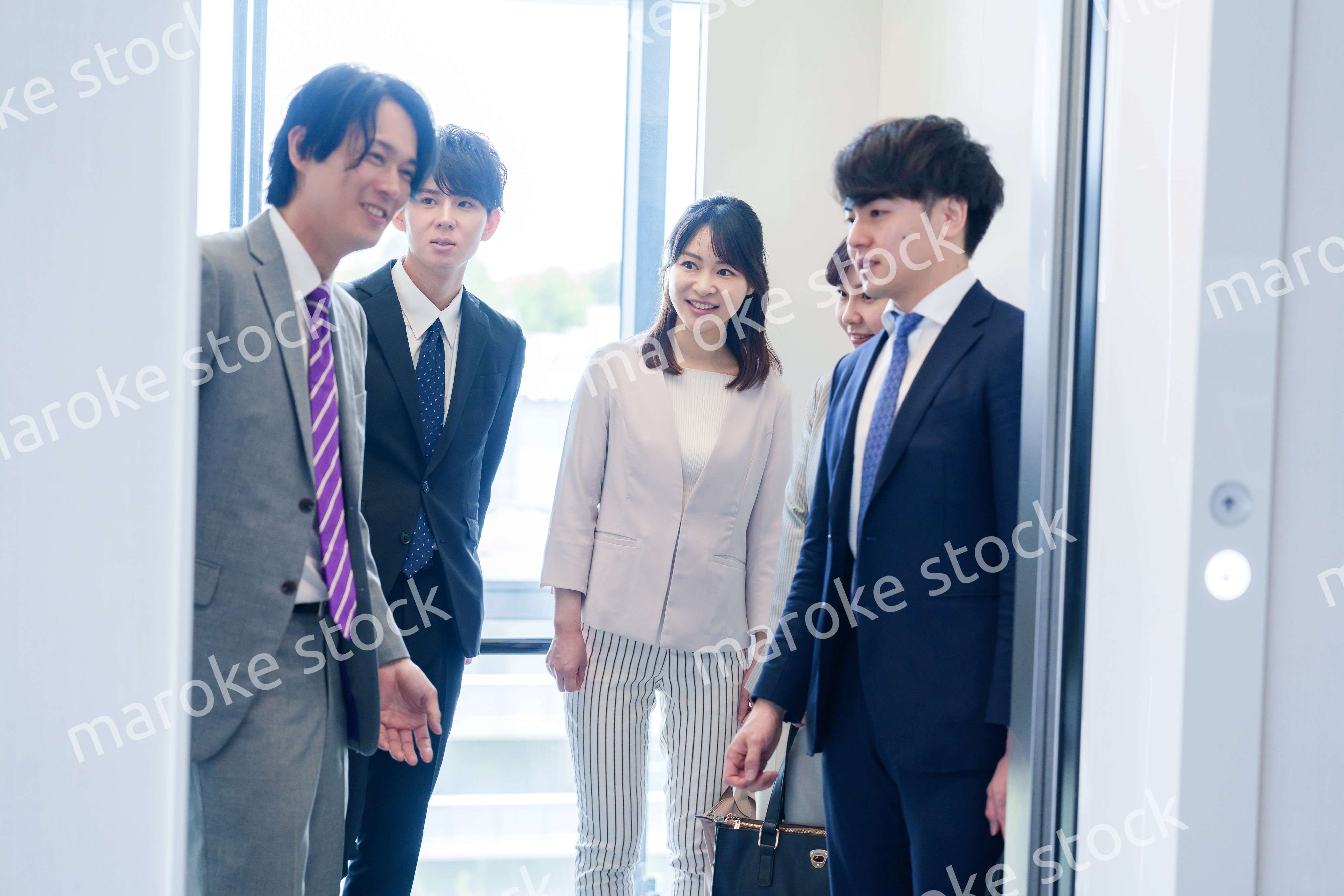 オフィスでエレベーターに乗るビジネスパーソン