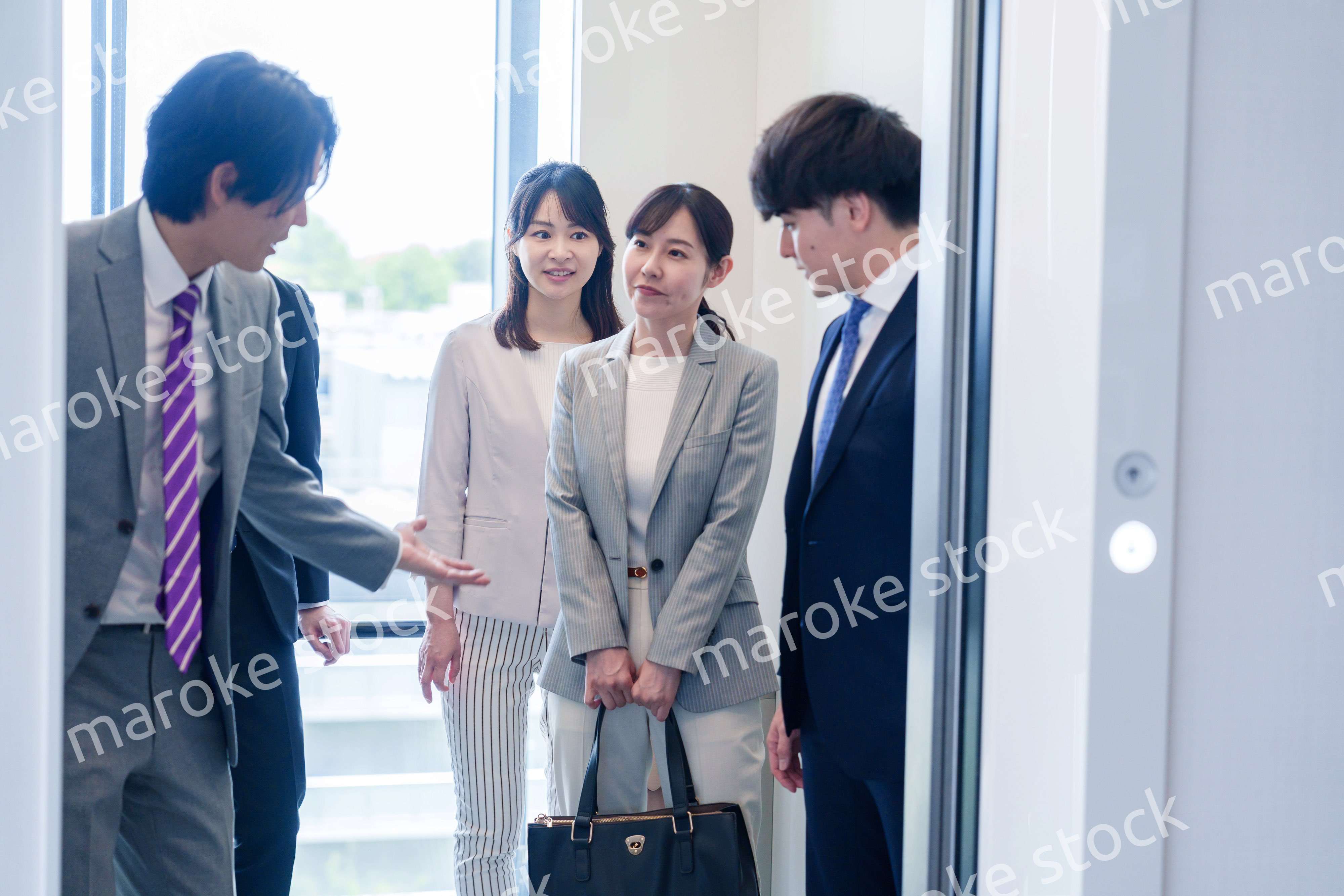 オフィスでエレベーターに乗るビジネスパーソン
