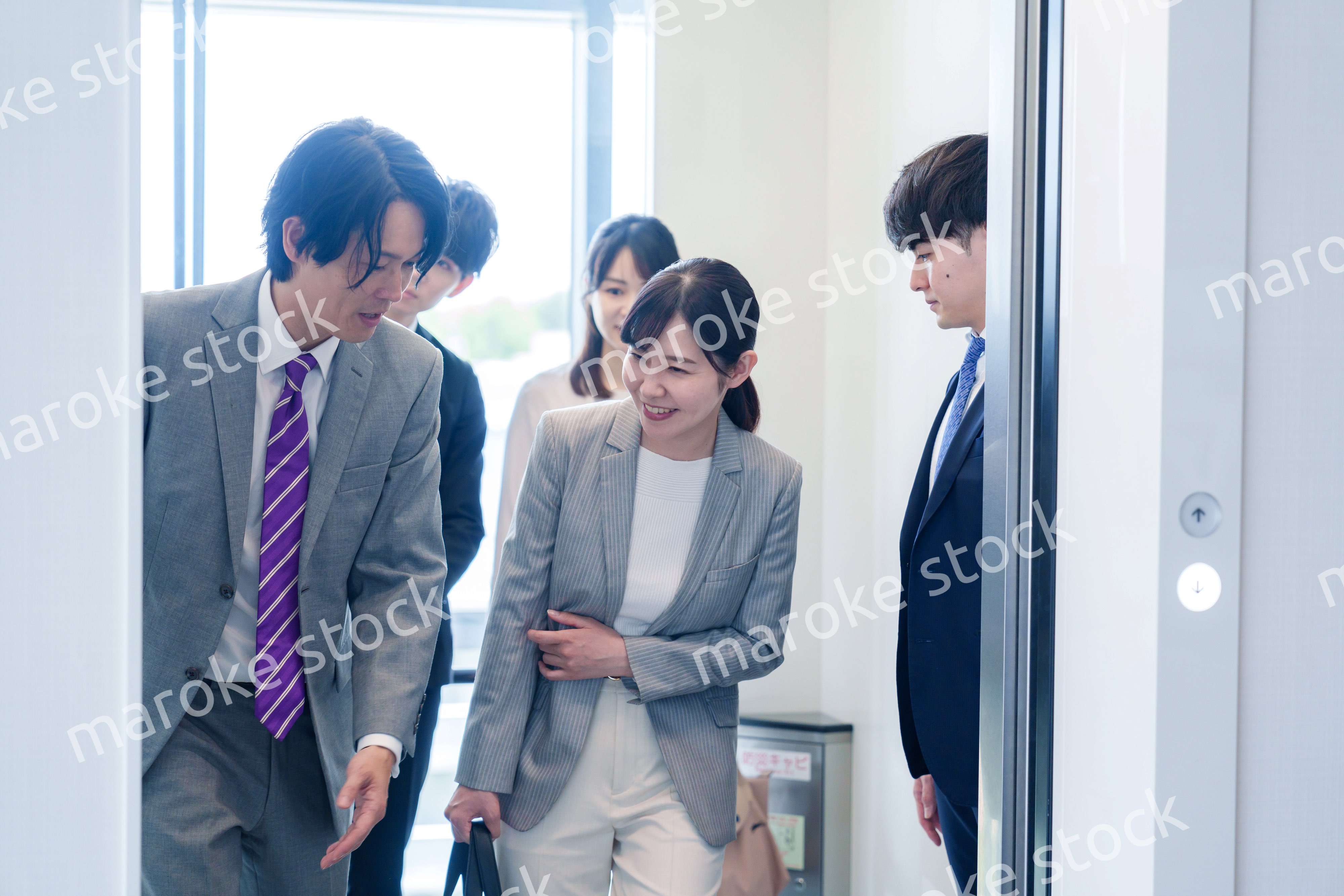 オフィスでエレベーターに乗るビジネスパーソン