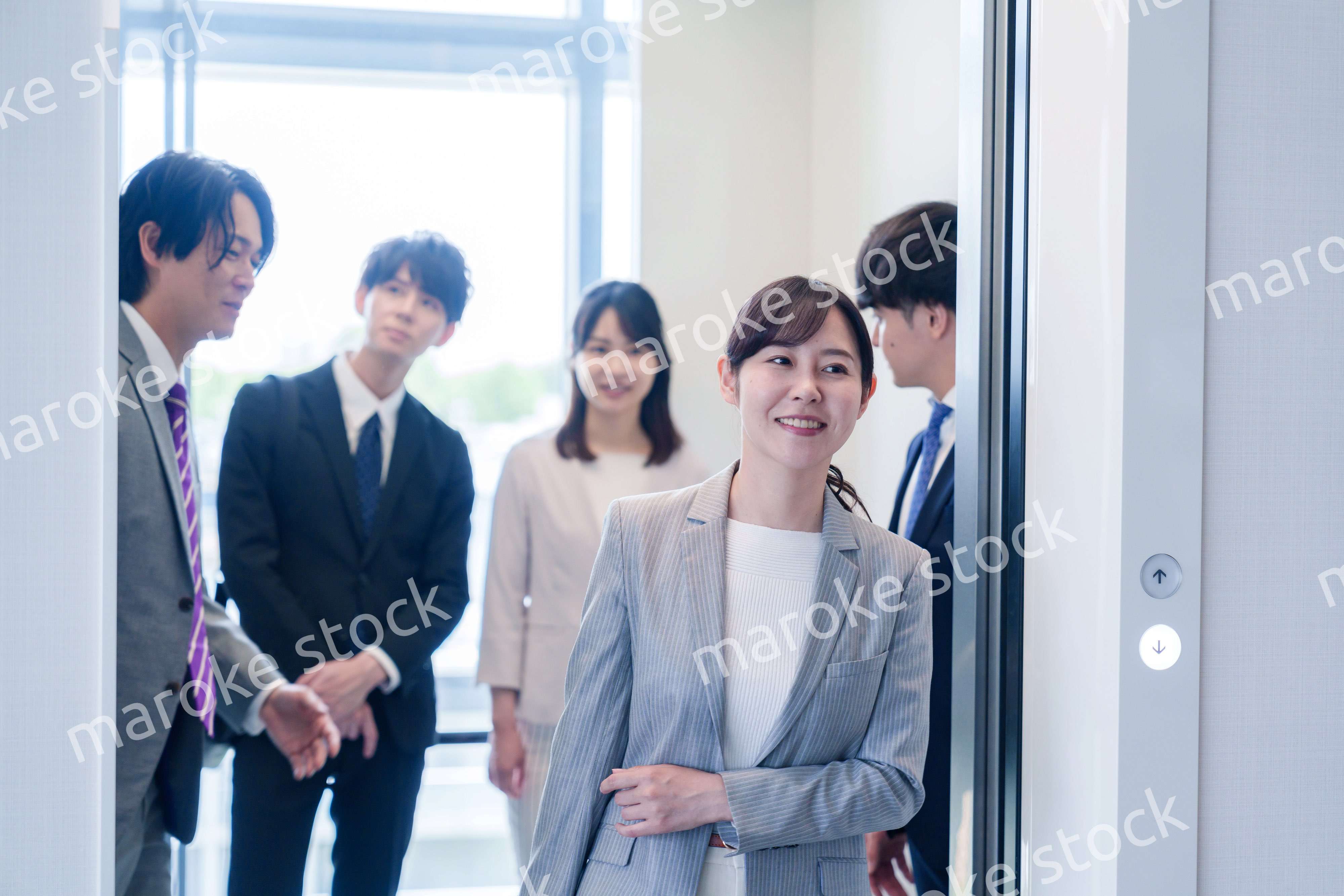 オフィスでエレベーターに乗るビジネスパーソン