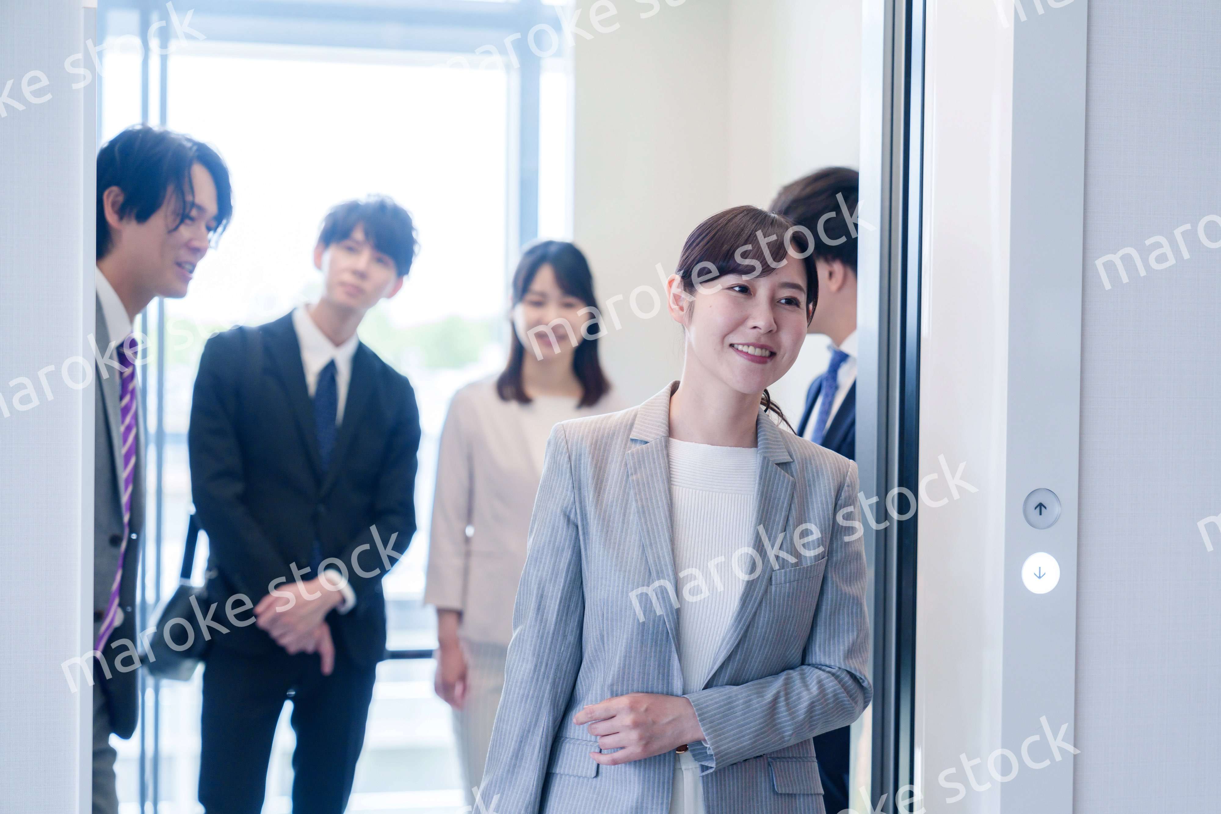 オフィスでエレベーターに乗るビジネスパーソン