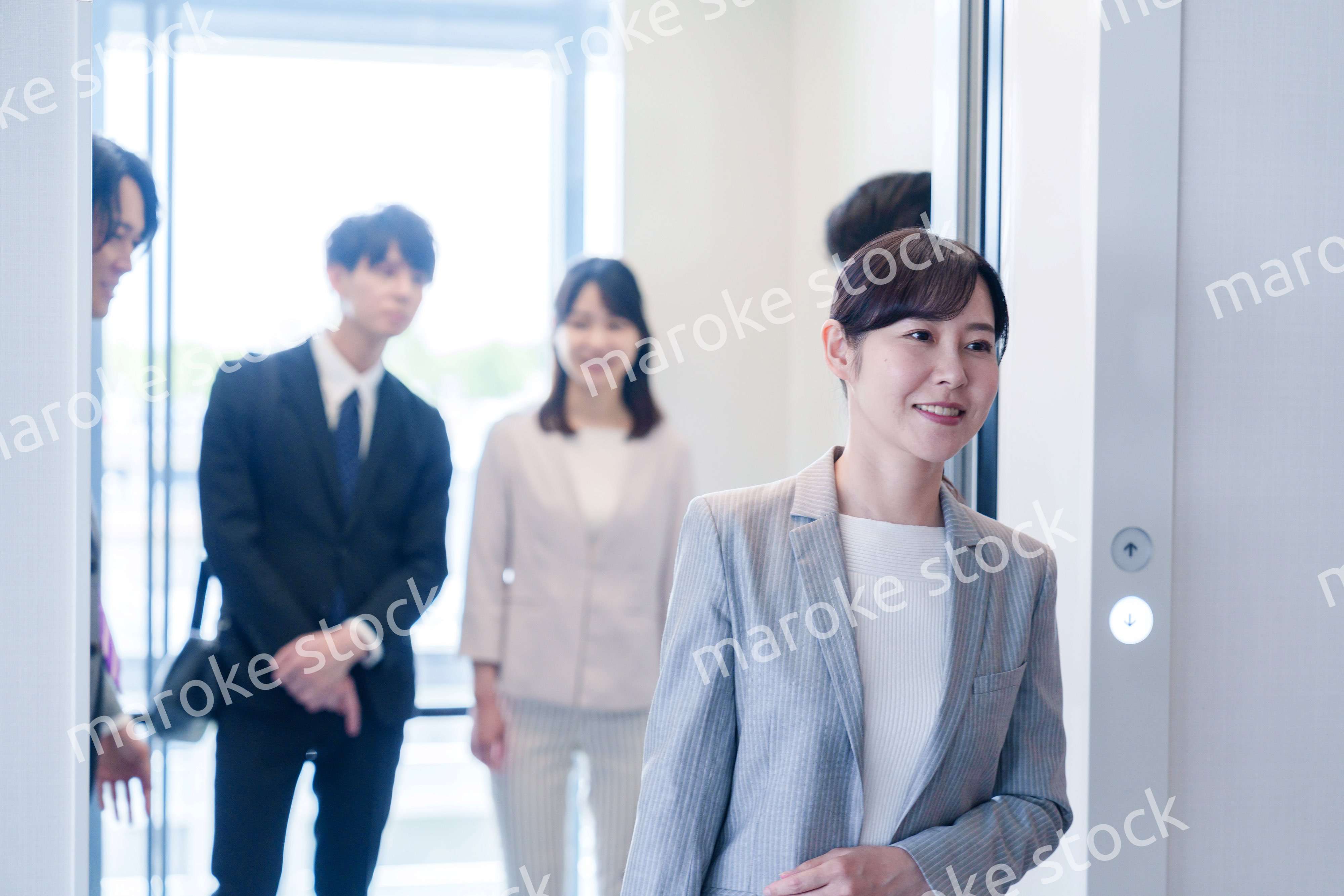 オフィスでエレベーターに乗るビジネスパーソン